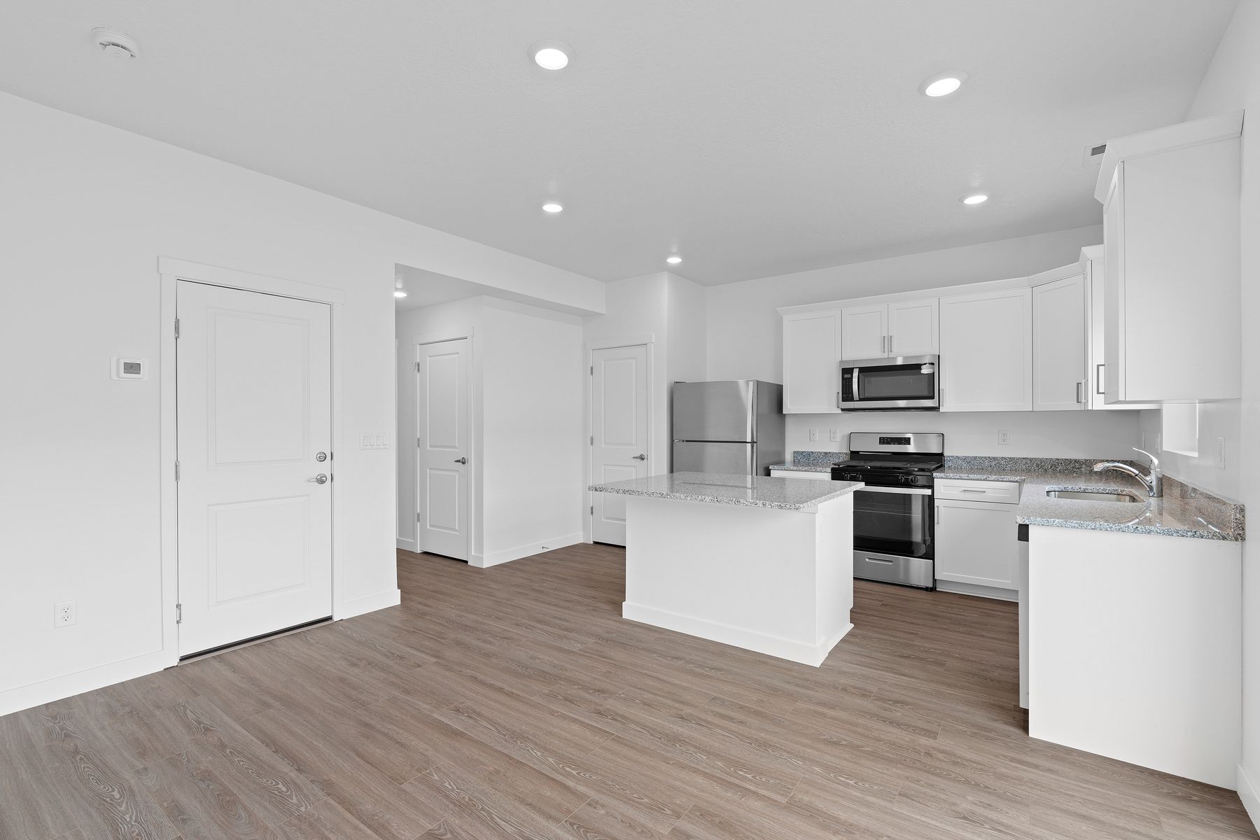 The kitchen has beautiful white wood cabinetry.