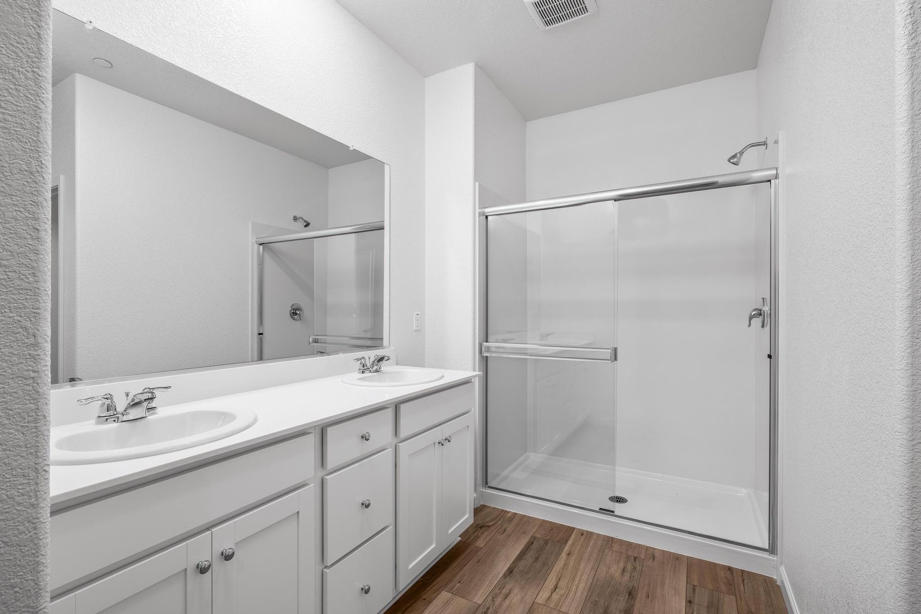 The master bathroom has a dual sink vanity and a step in shower.
