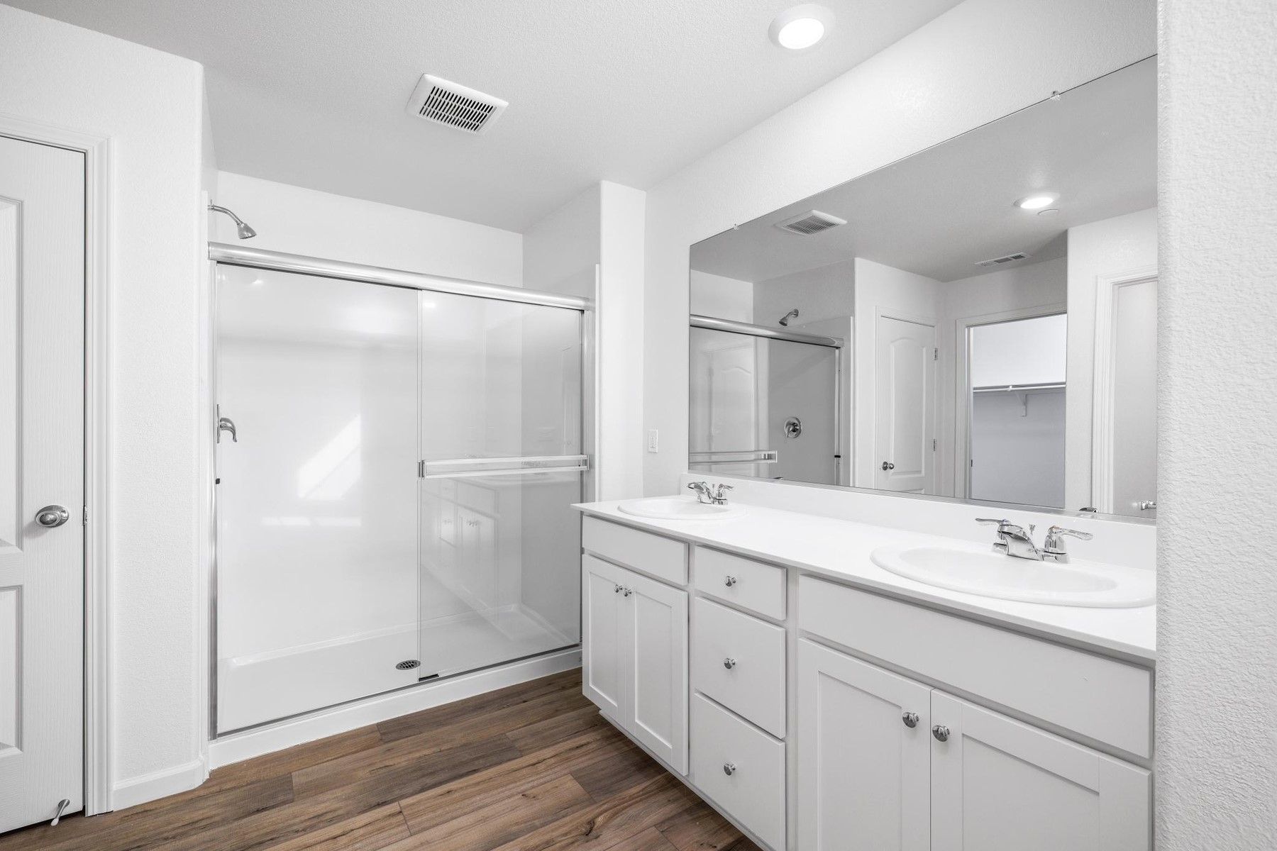 The master bathroom has a dual sink vanity and a step in shower.