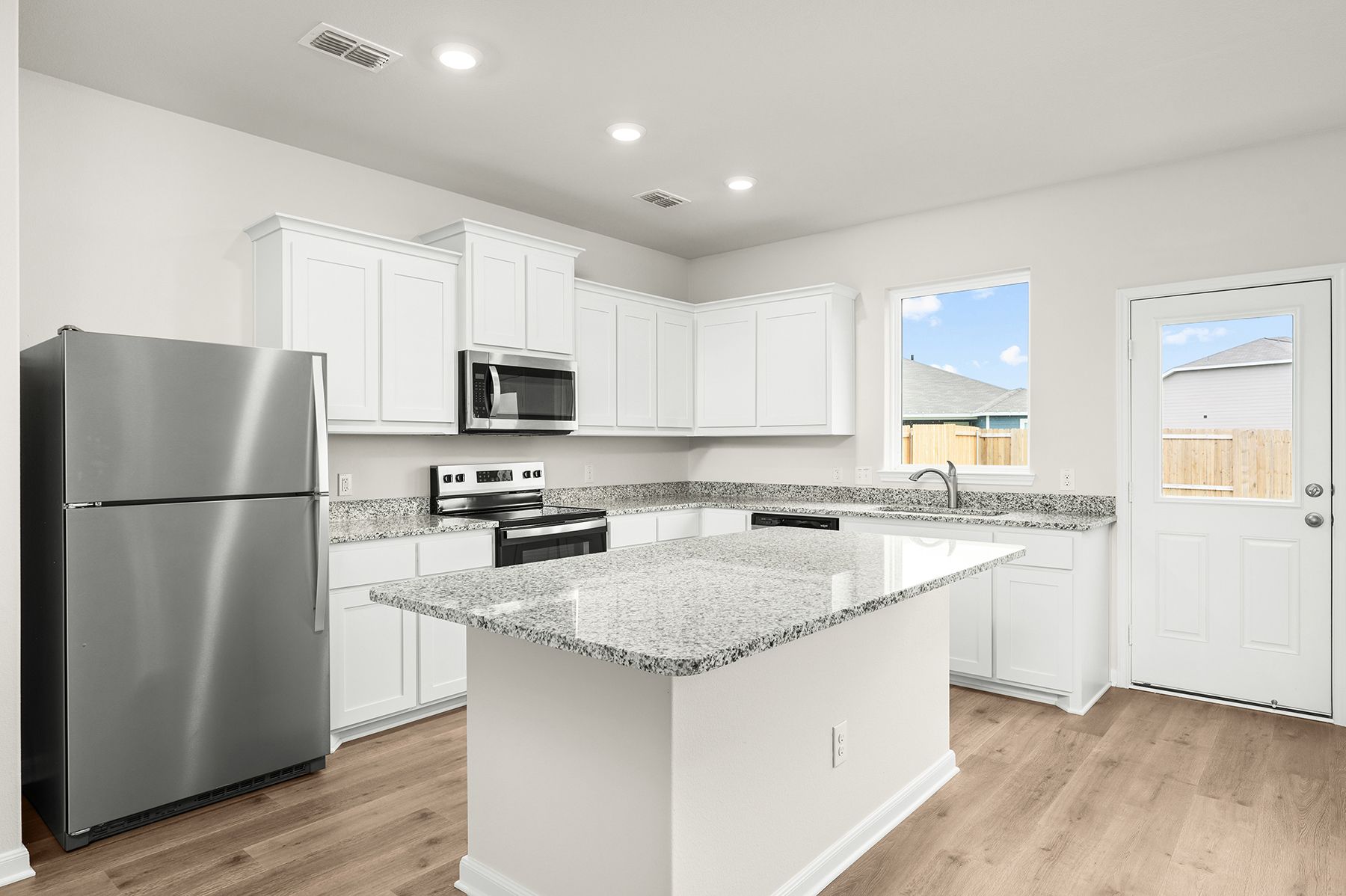 The kitchen has beautiful white wood cabinetry.