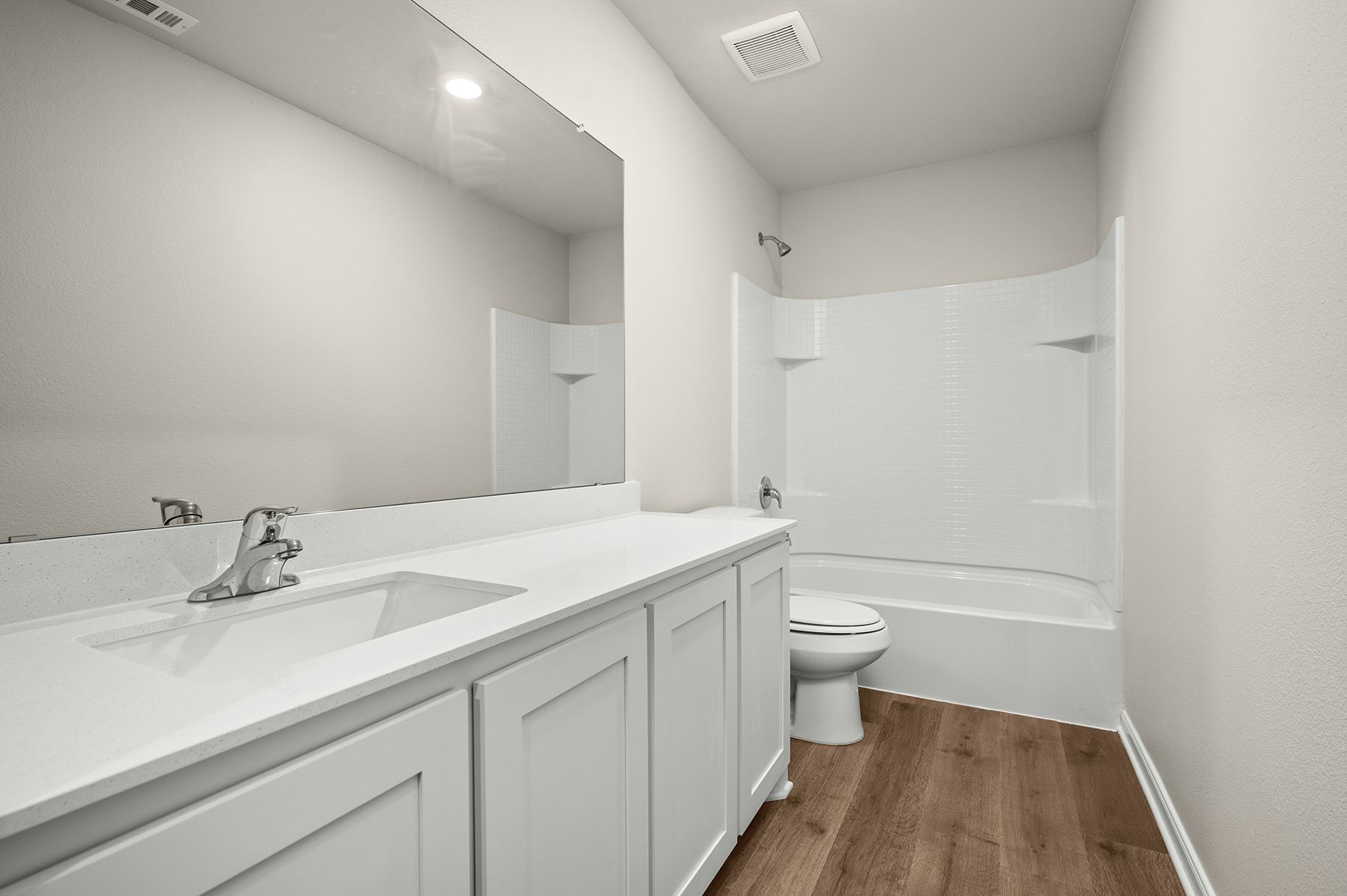 The secondary bathroom has a sprawling vanity and shower tub combo.
