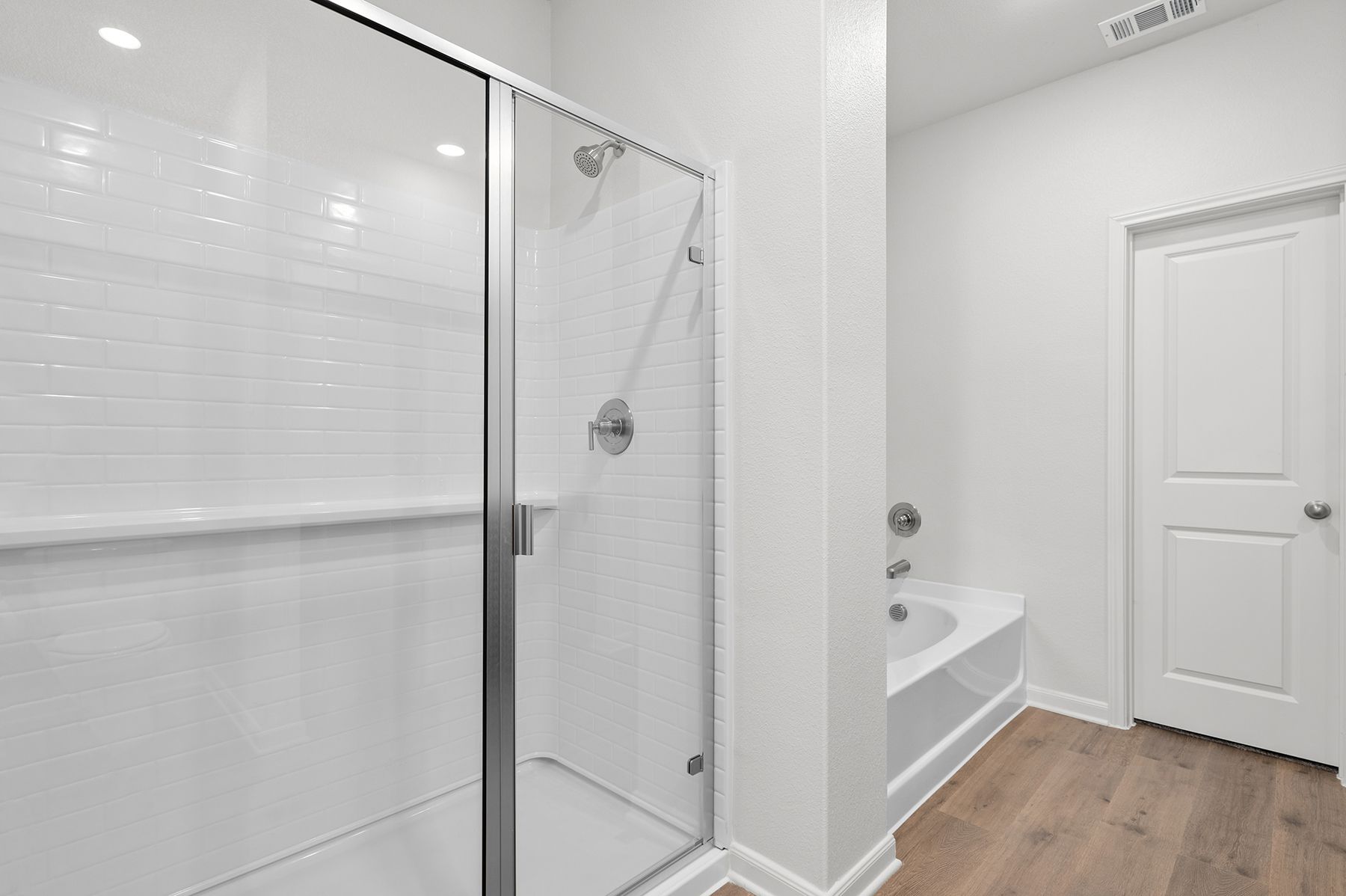 The master bathroom has a glass, walk-in shower and garden tub.