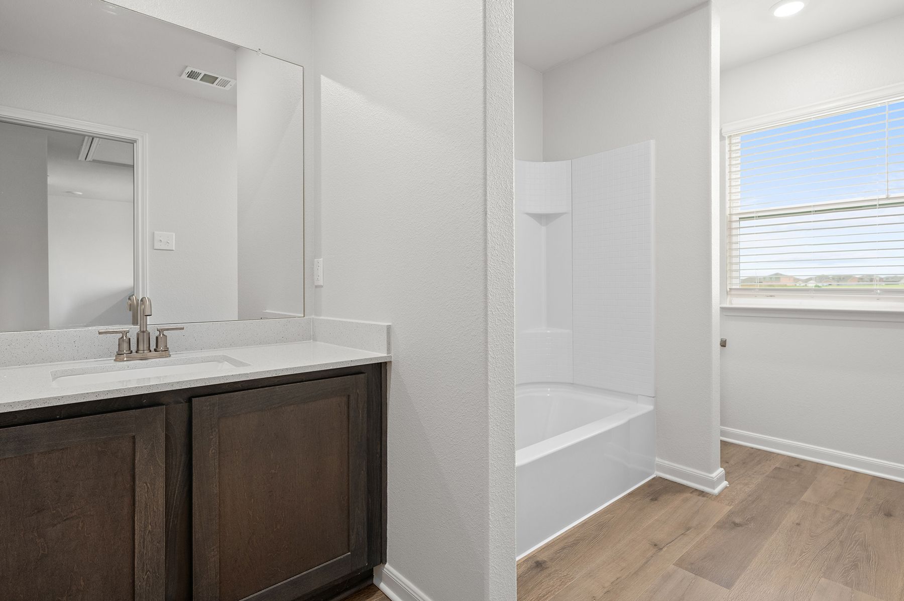 The secondary bathroom has a large vanity space and shower-tub combo.