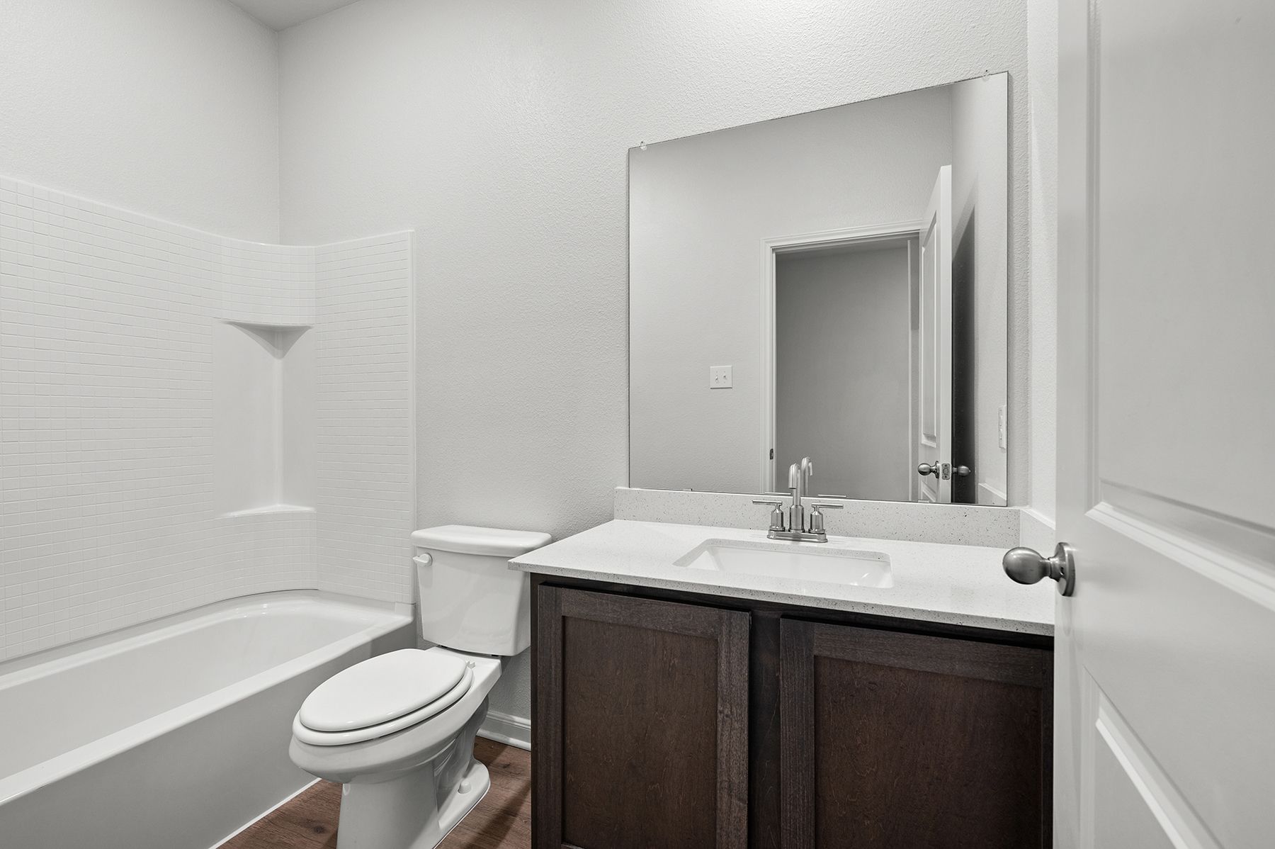 The secondary bathroom has a large vanity and a shower-tub combo.