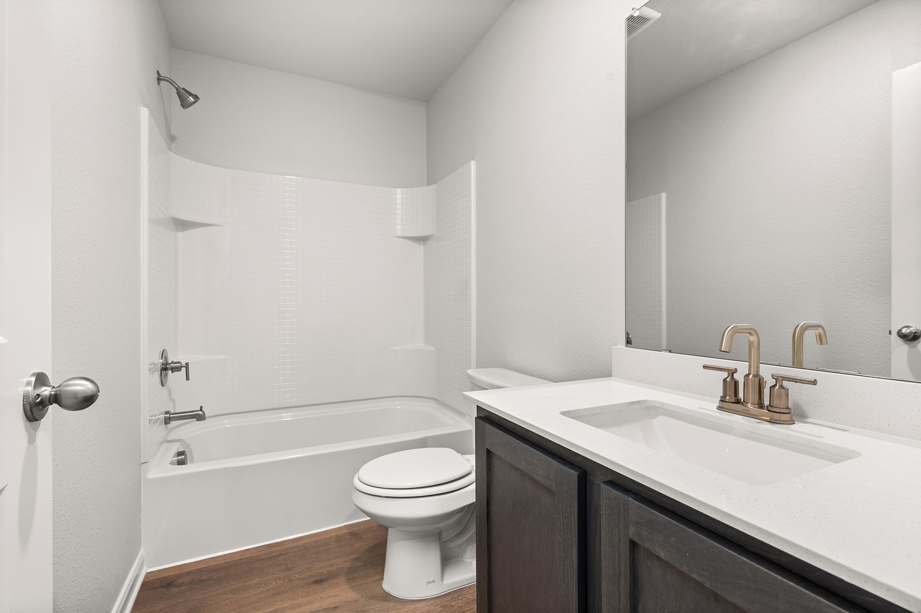 The secondary bathroom has a large vanity and shower-tub combo.