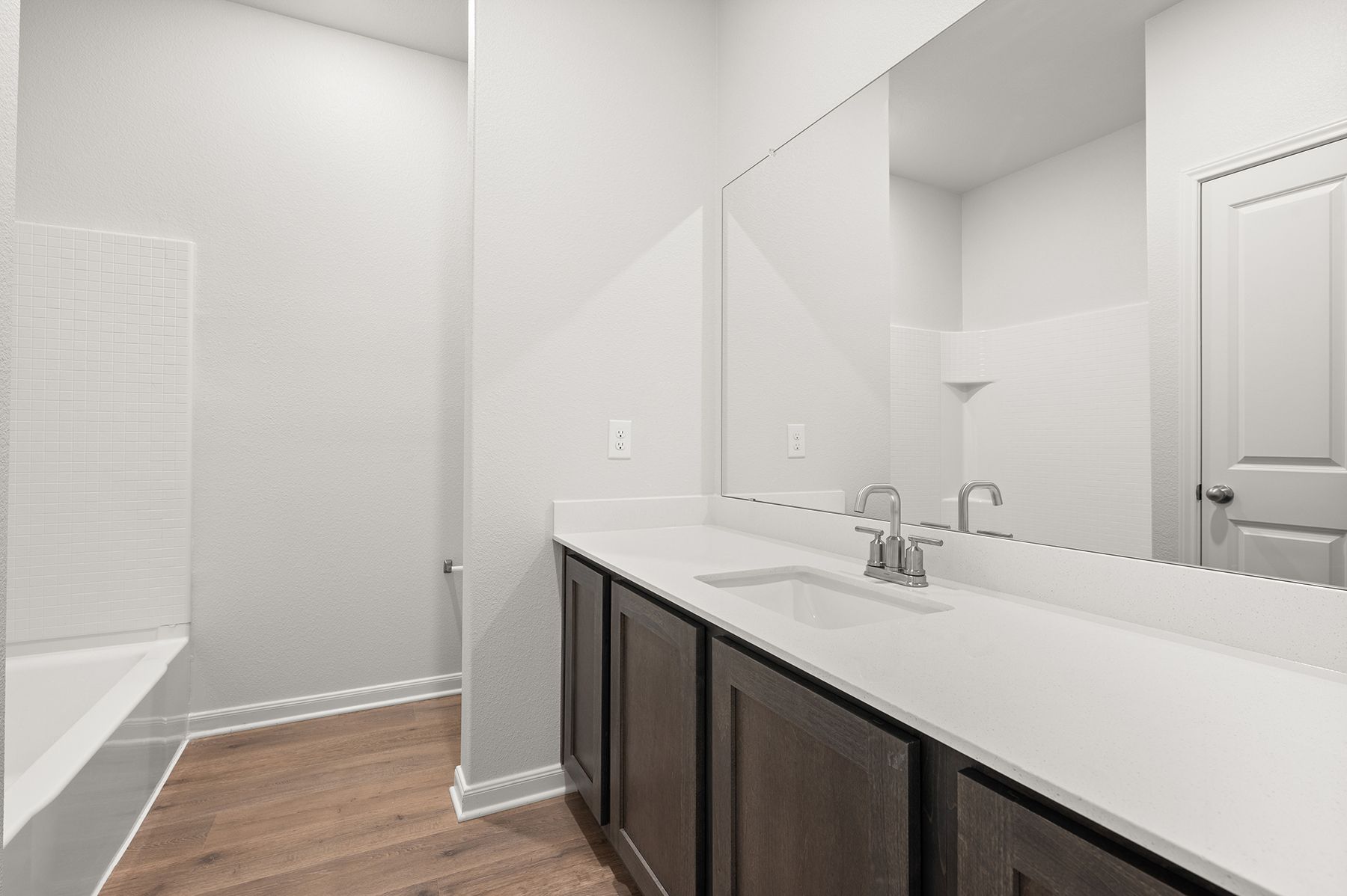 The seconadry bathroom has a large vanity and a shower-tub combo.