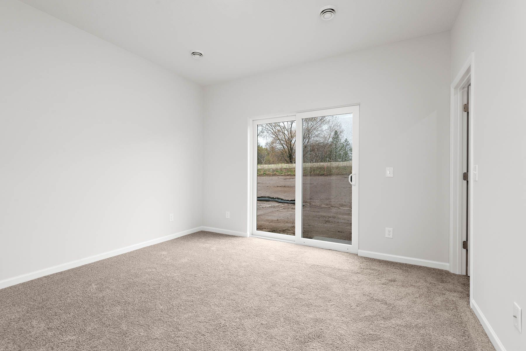 The master bedroom is spacious and has carpet.
