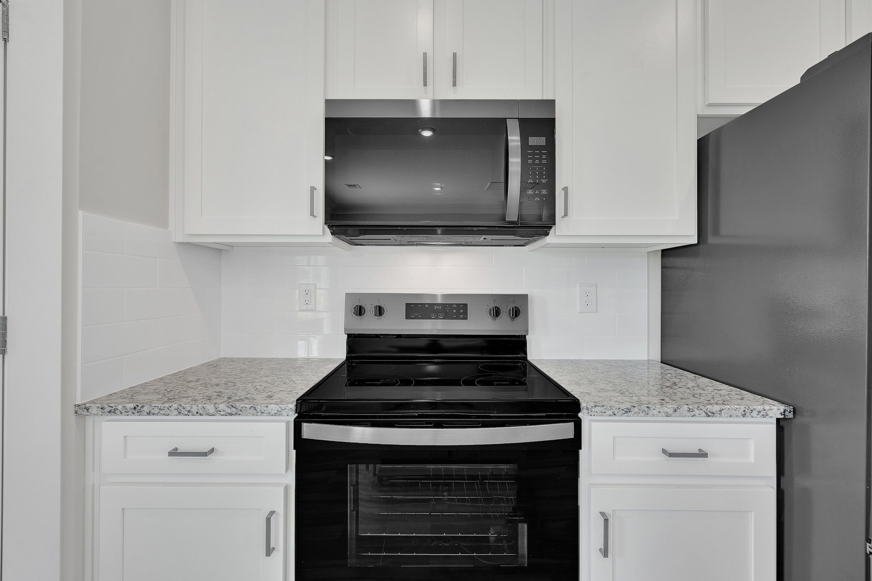 The kitchen has designer wood cabinetry. 