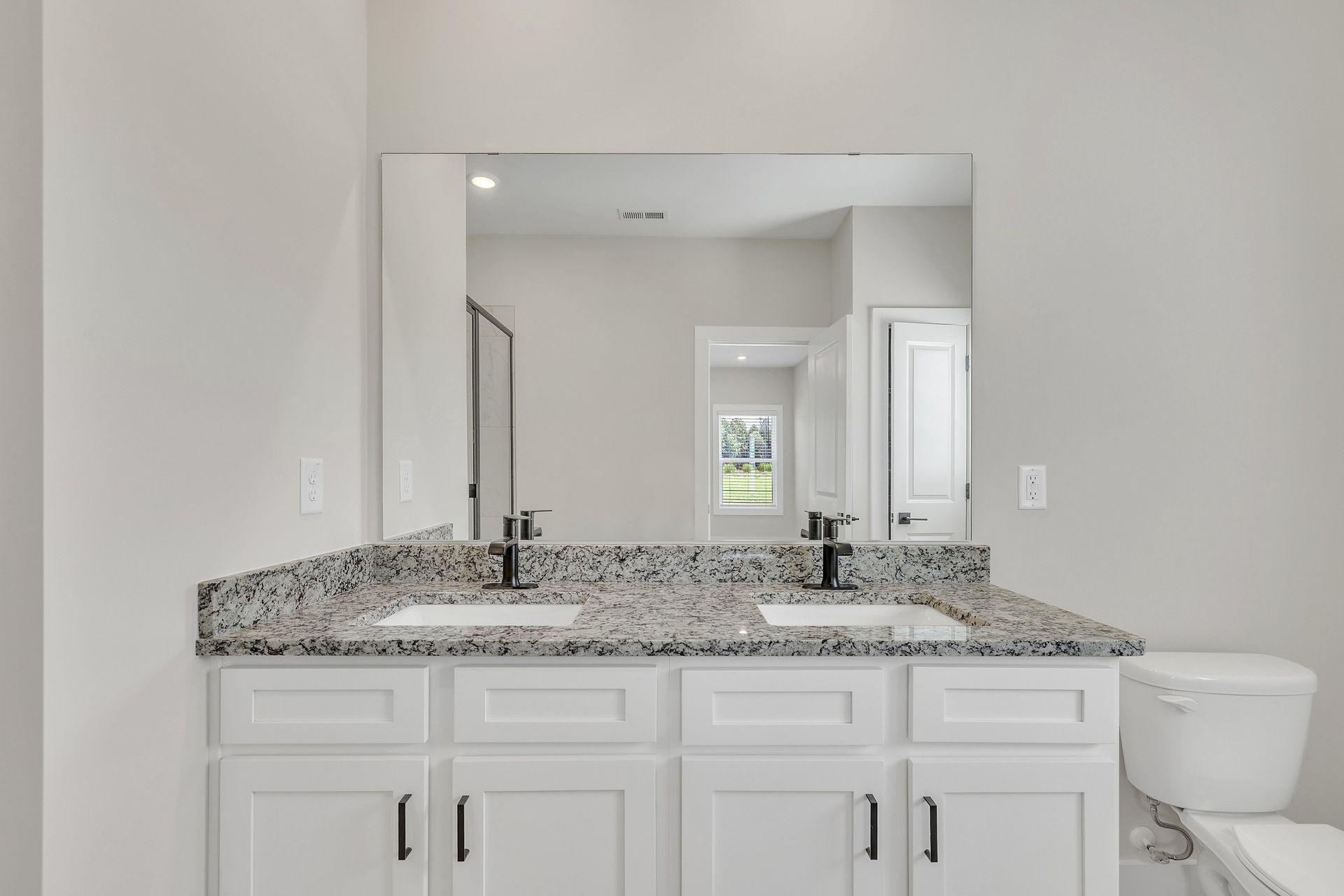 The secondary bathroom has granite countertops