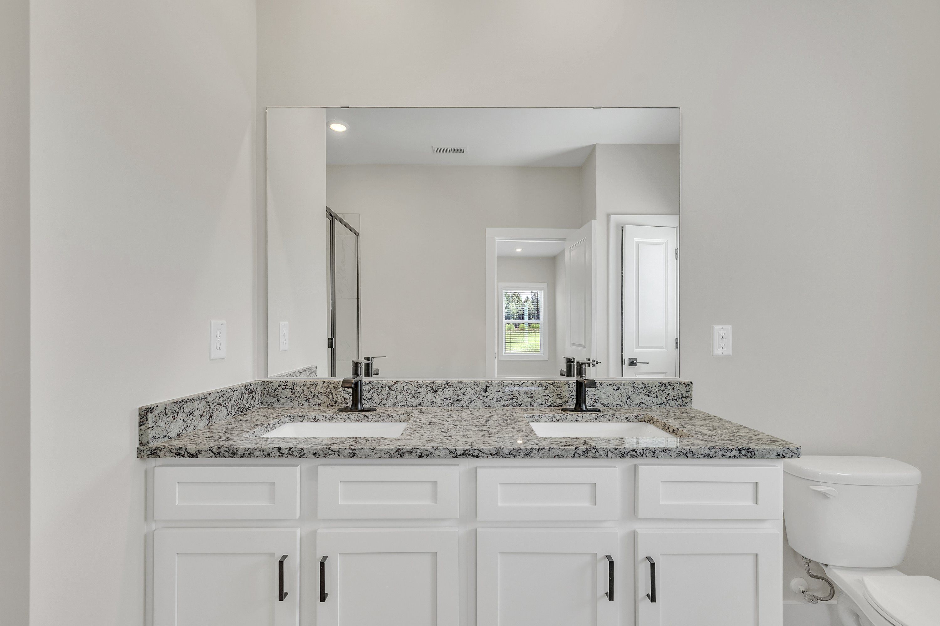 The secondary bathroom has granite countertops