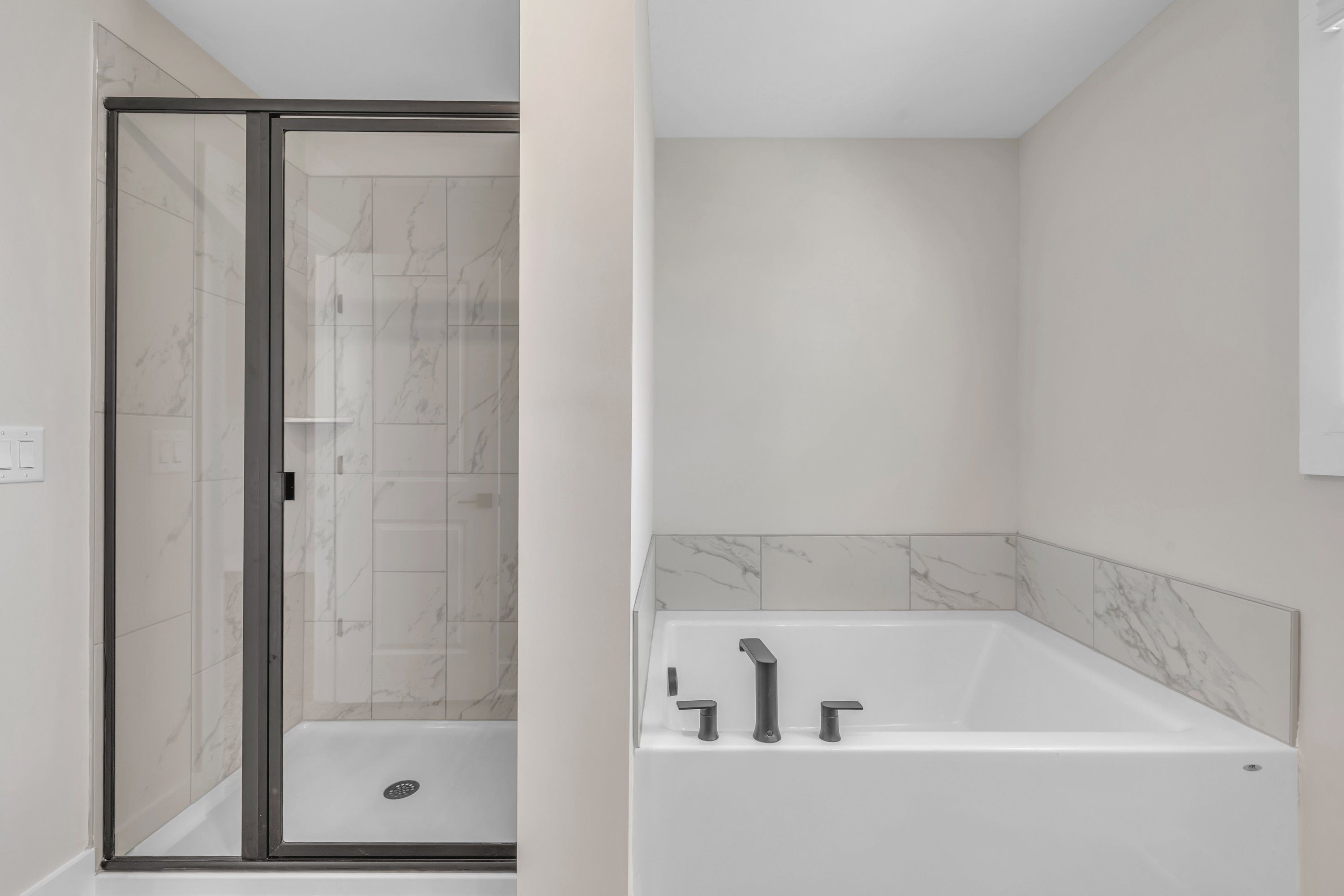 The master bathroom has a large soaking tub and glass-enclosed shower. 