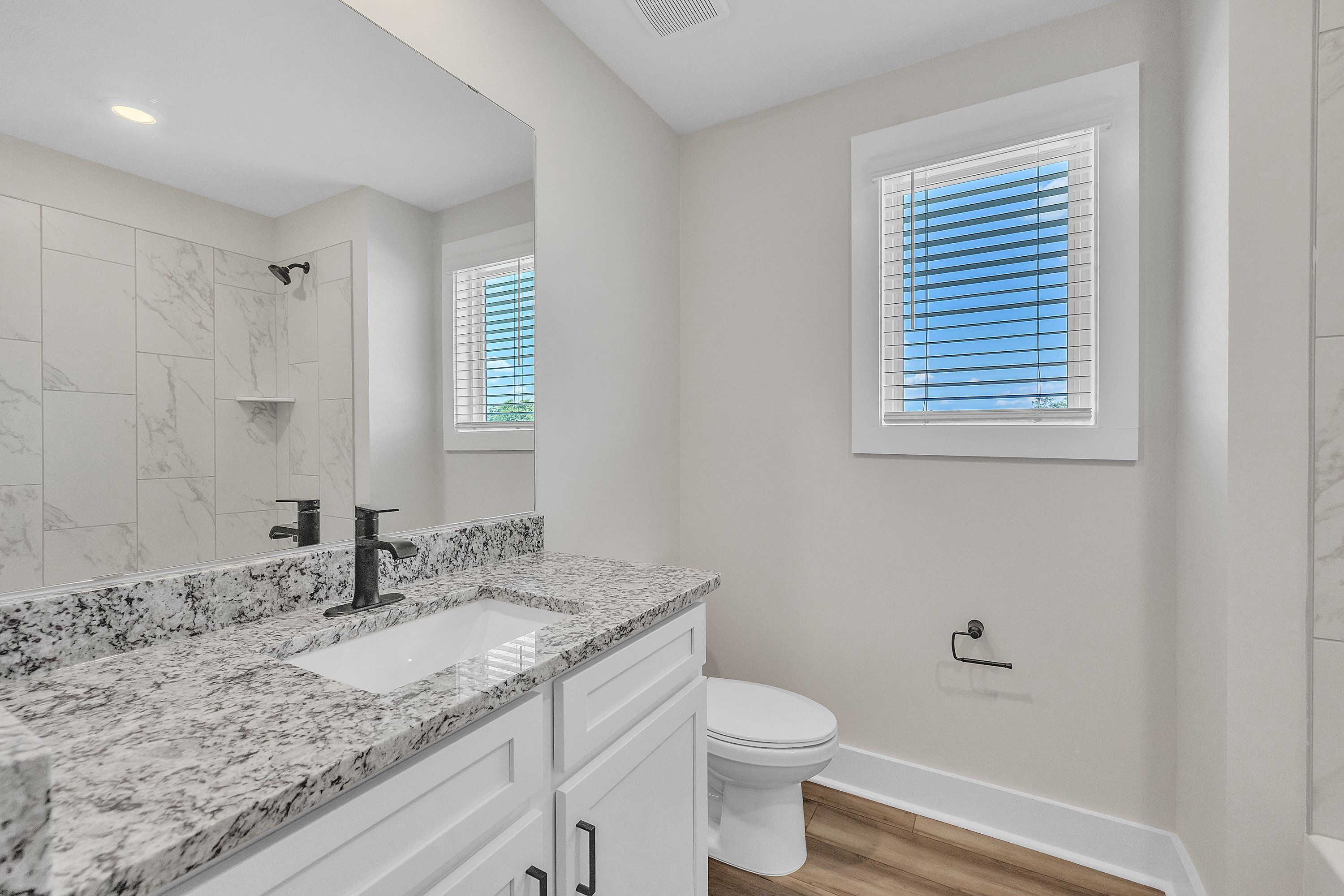 This bathroom has granite countertops.