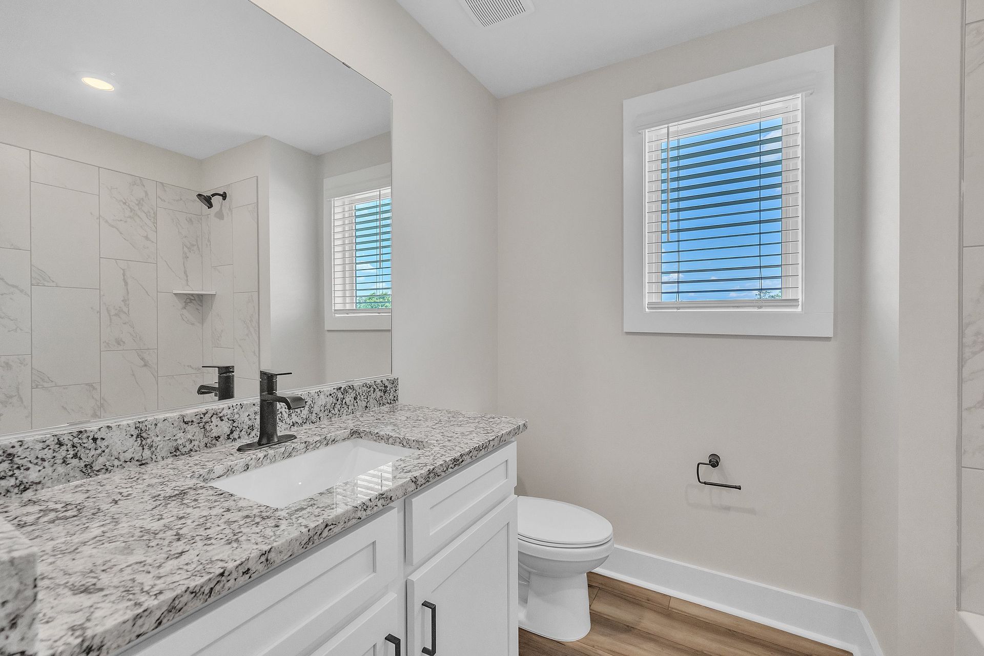 This bathroom has granite countertops.