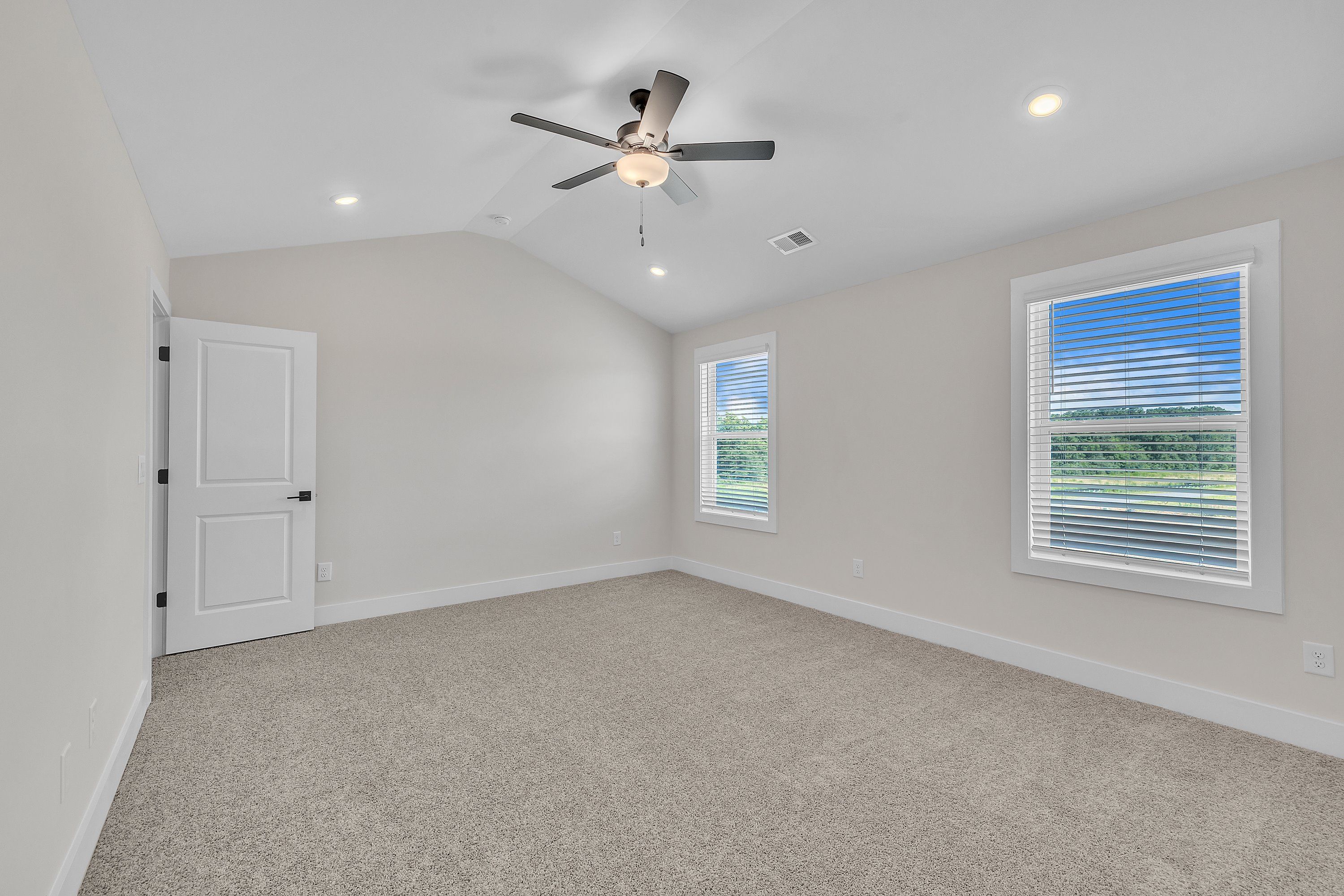 The master bedroom has lots of windows to let in natural light.