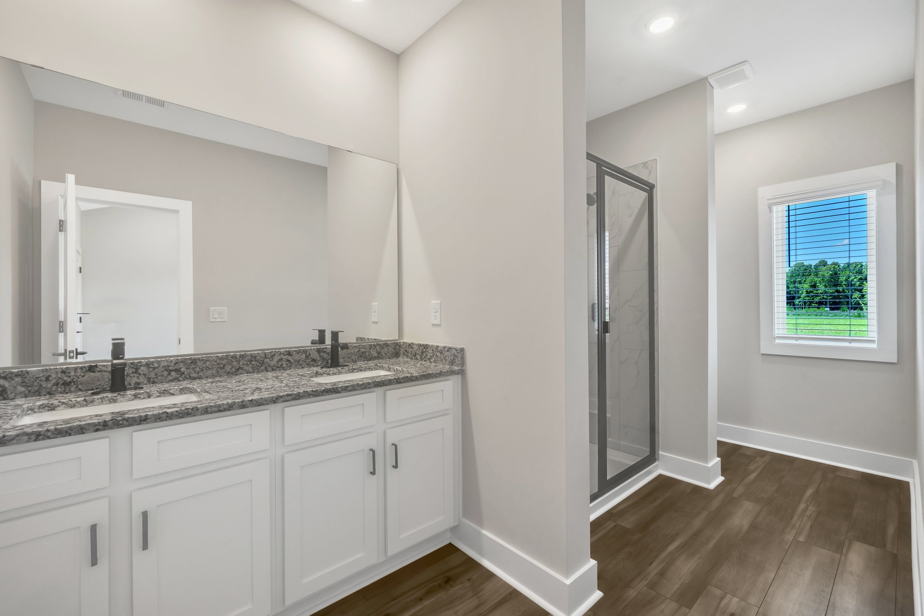 The master bathroom has double sinks and glass-enclosed shower. 