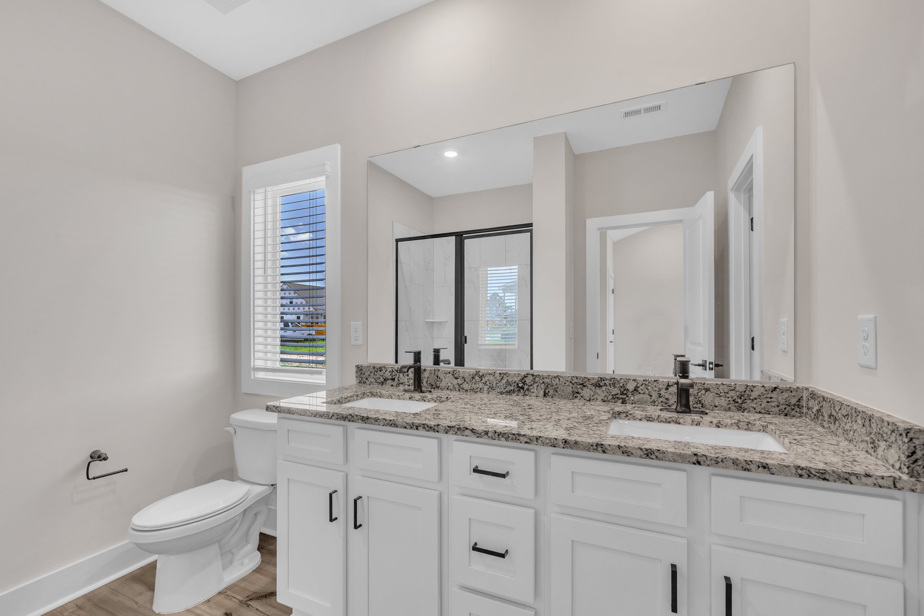 The master bathroom has double sinks and glass-enclosed shower. 