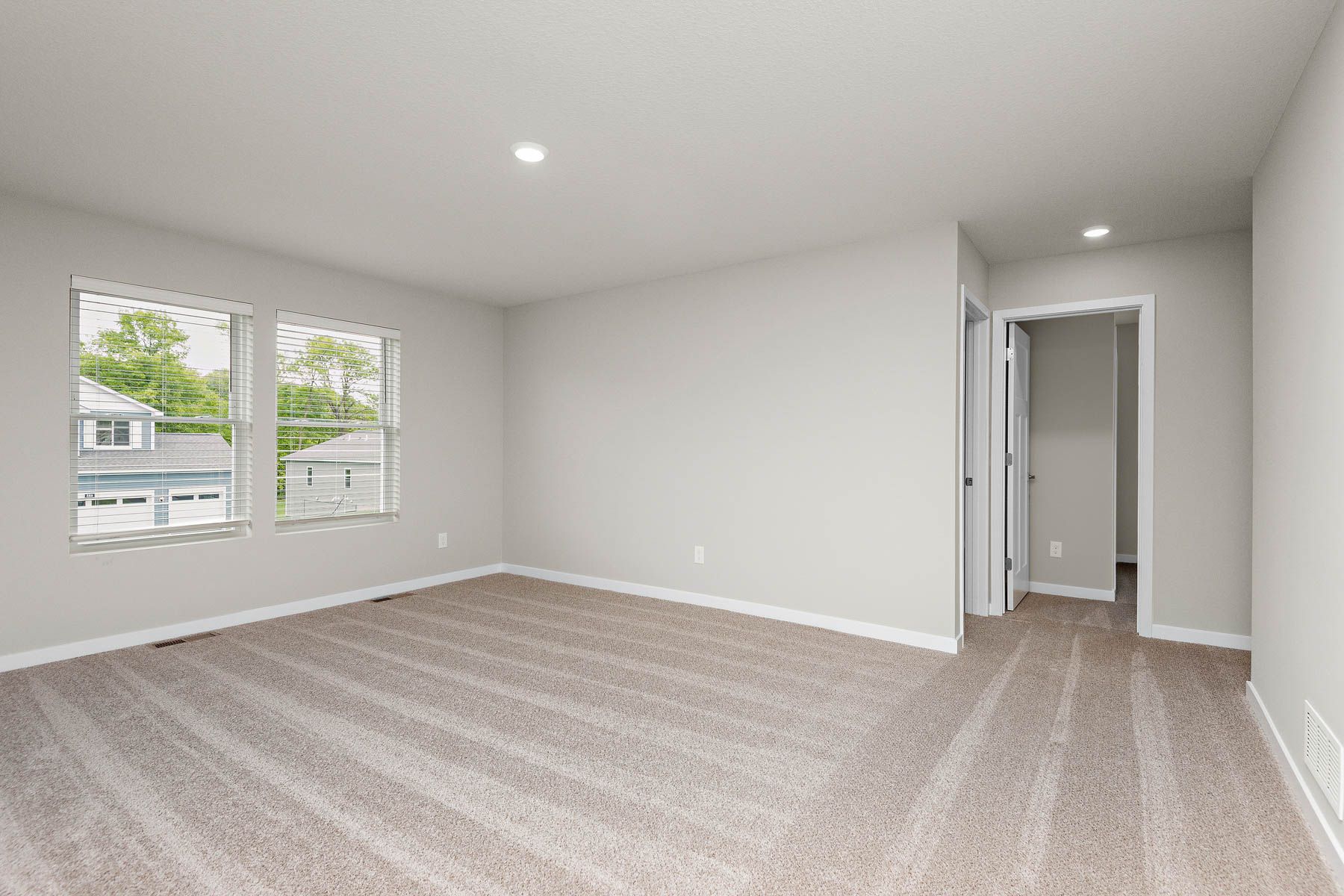 The master bedroom is spacious and has carpet.