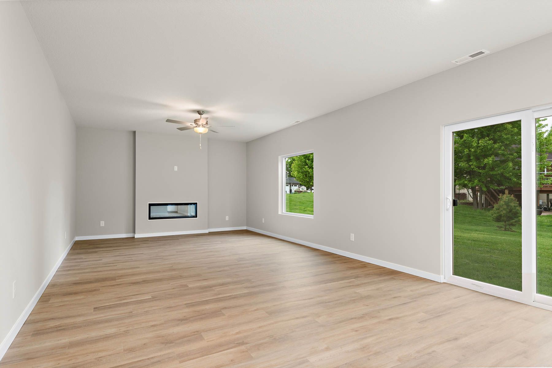 The family room is spacious with a ceiling fan and fireplace