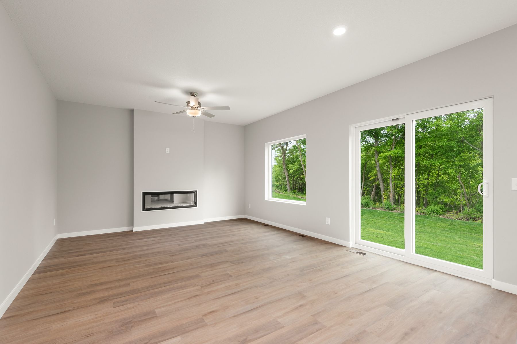 The family room is spacious with a ceiling fan and a fireplace