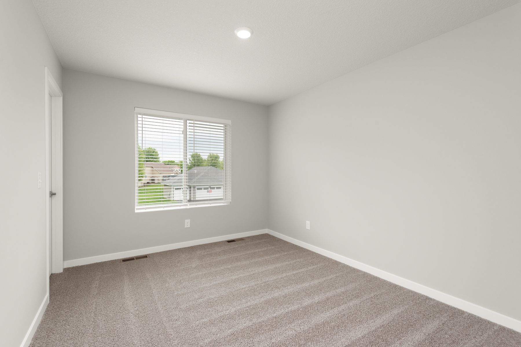 The master bedroom is spacious and has carpet.