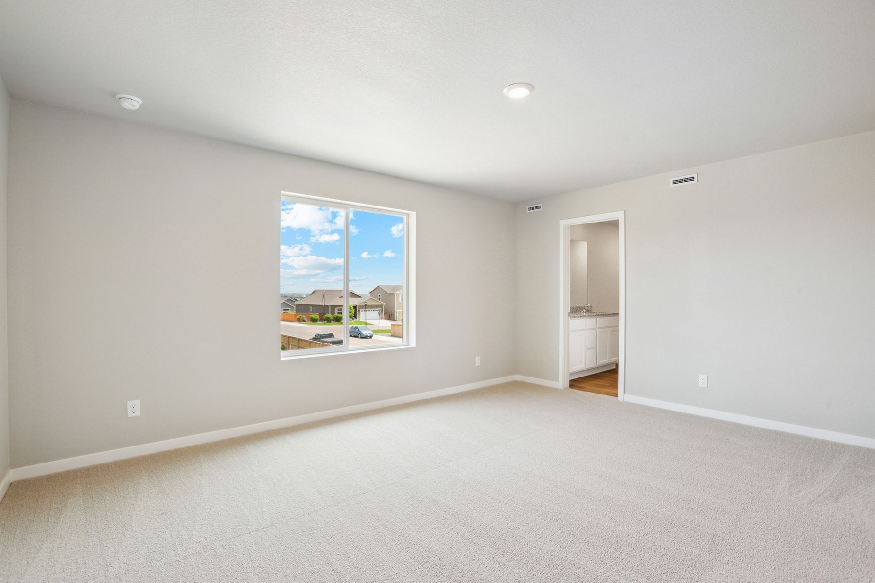 The master bedroom is spacious and has carpet.