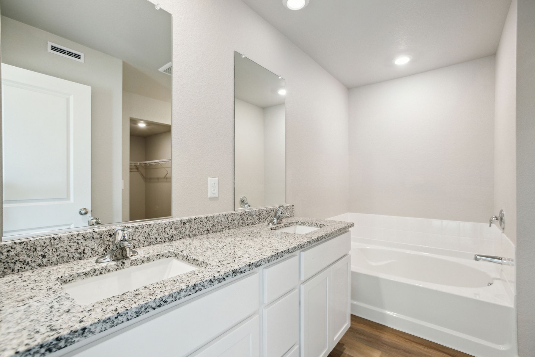 The master bathroom has a dual sink vanity with a step in shower and soaking tub.