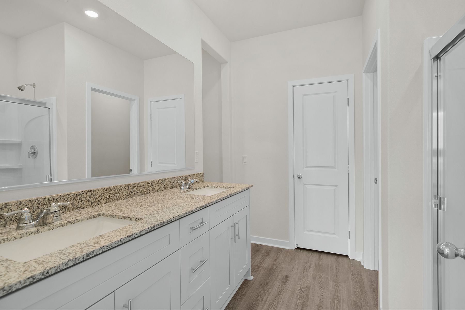 The master bathroom has a dual sink vanity and a step in shower.