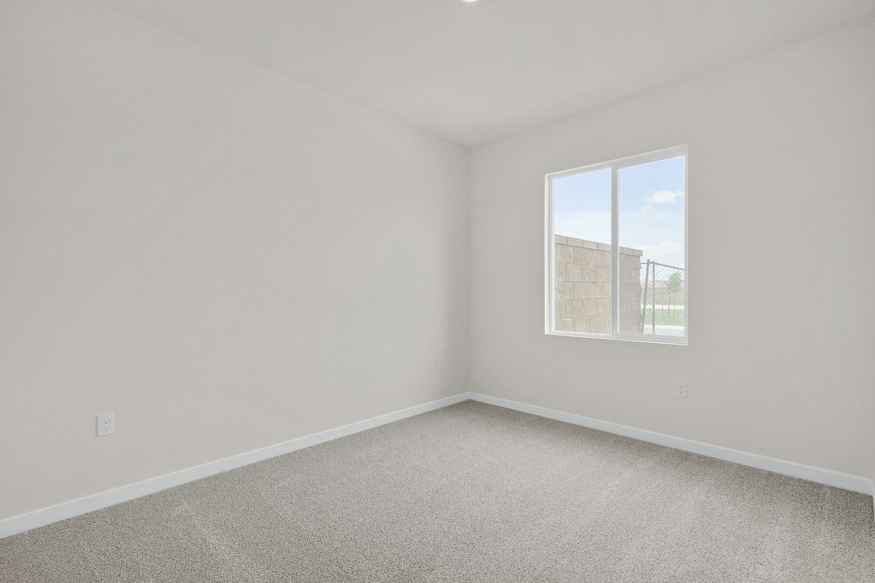 The master bedroom is spacious and has carpet.