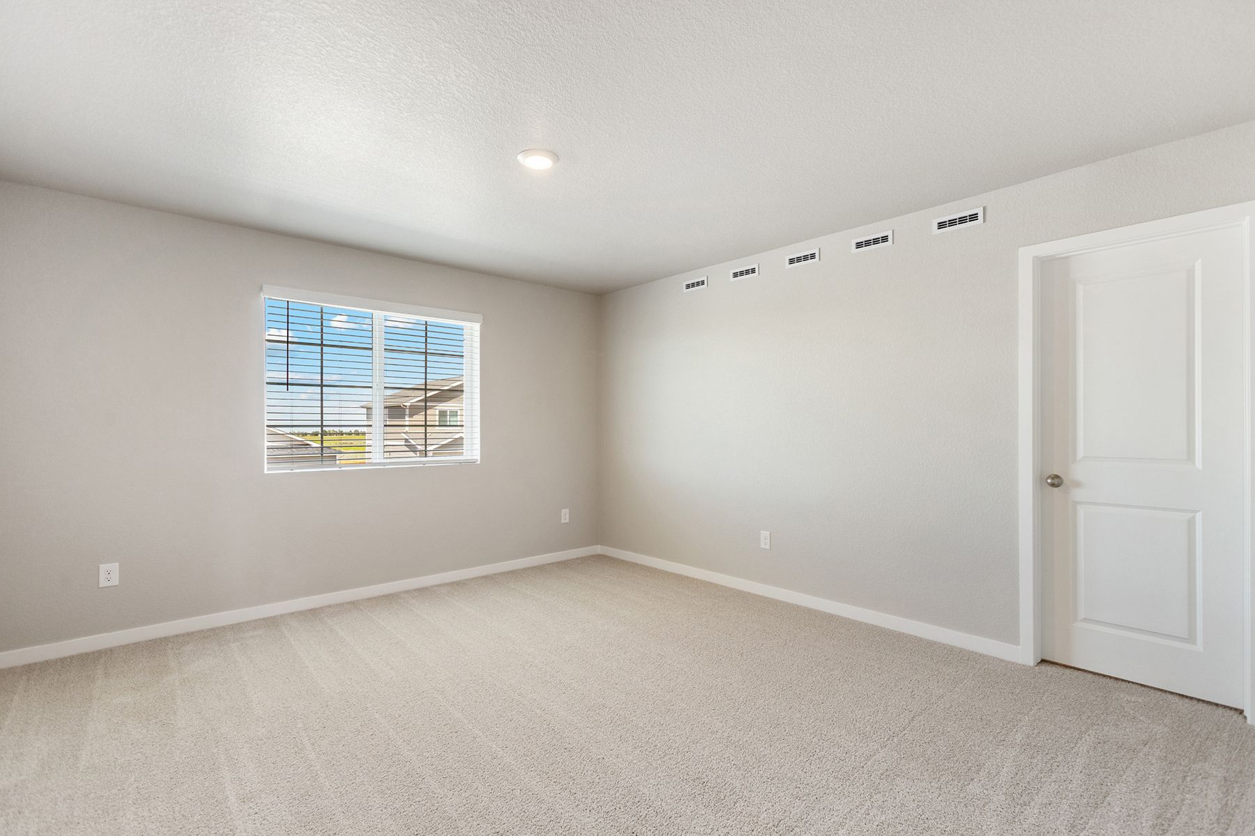 The master bedroom is spacious and has carpet.