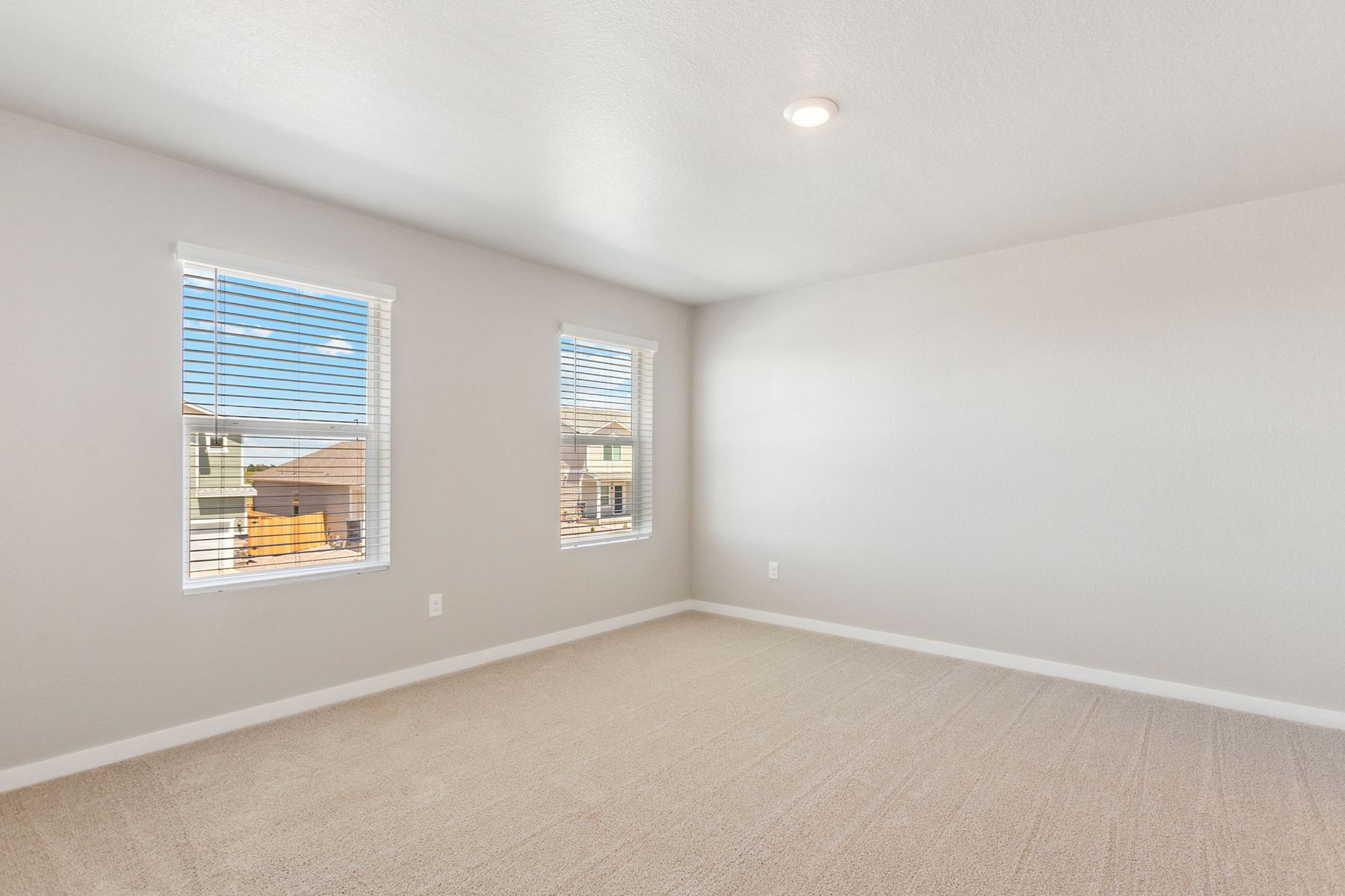 The master bedroom is spacious and has carpet.