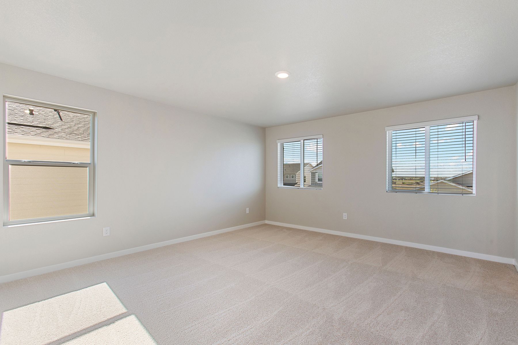 The master bedroom is spacious and has carpet.