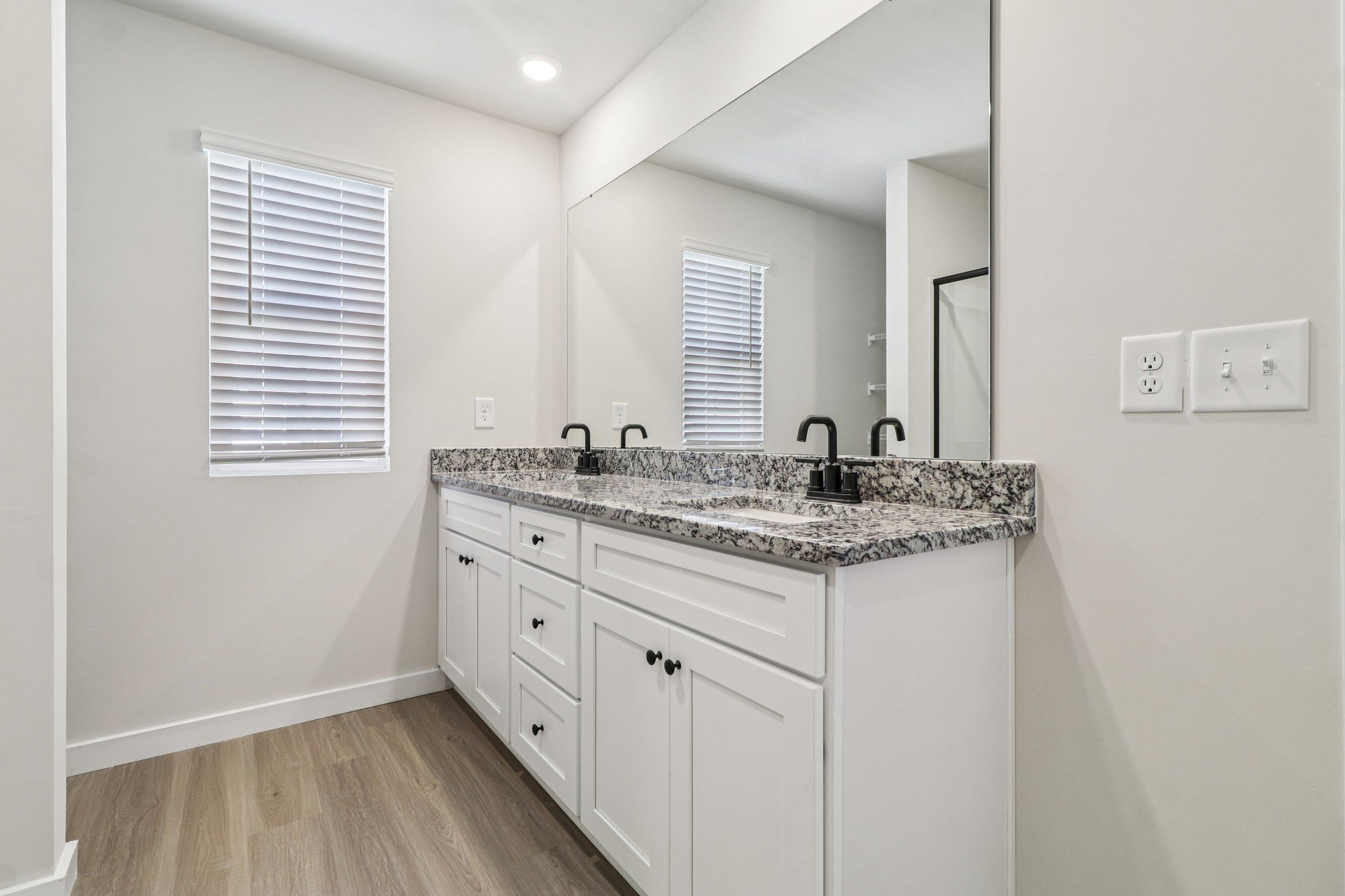 The master bathroom has double sinks and glass-enclosed shower. 