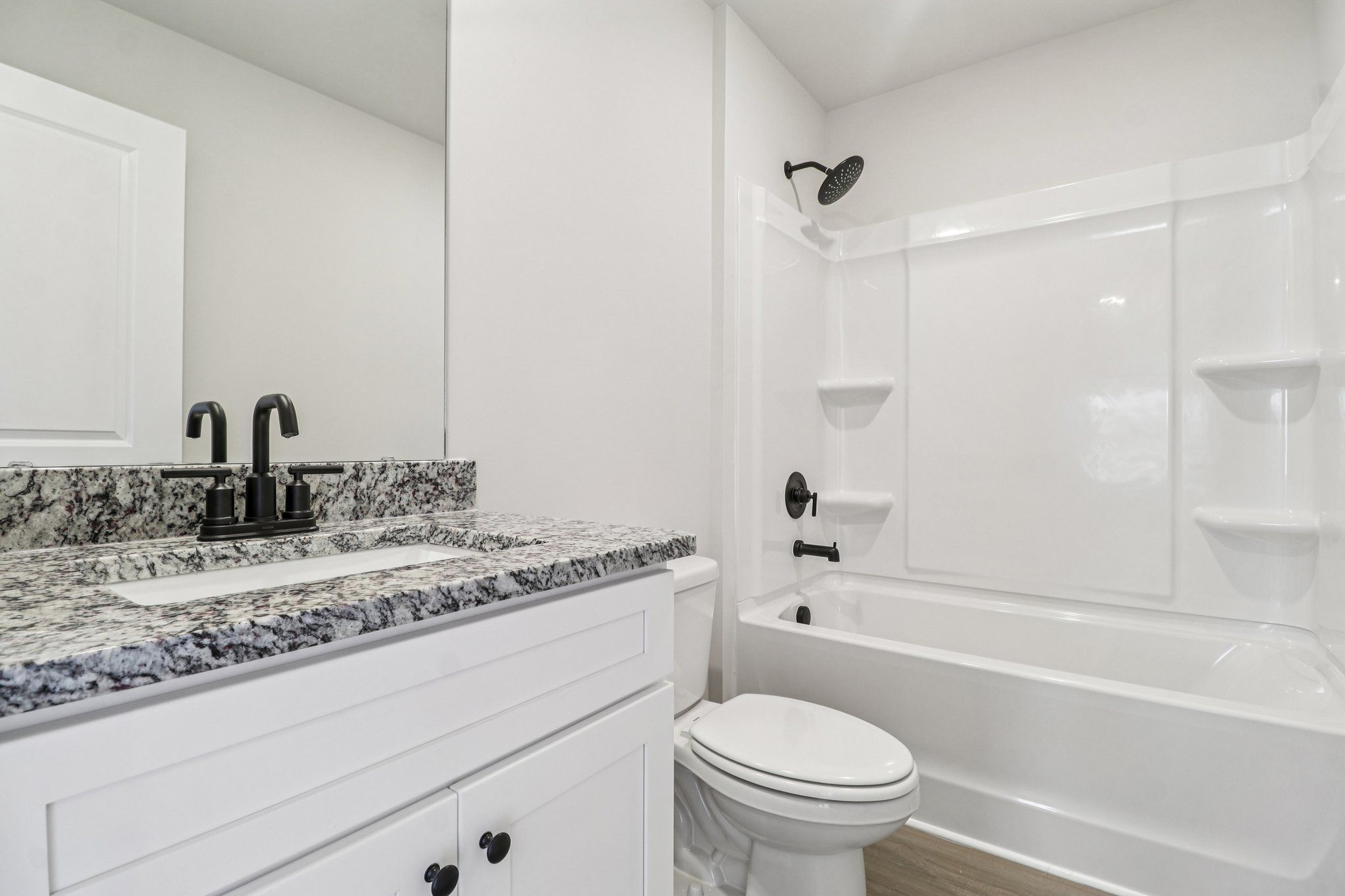 The secondary bathroom has carpet and a large window.