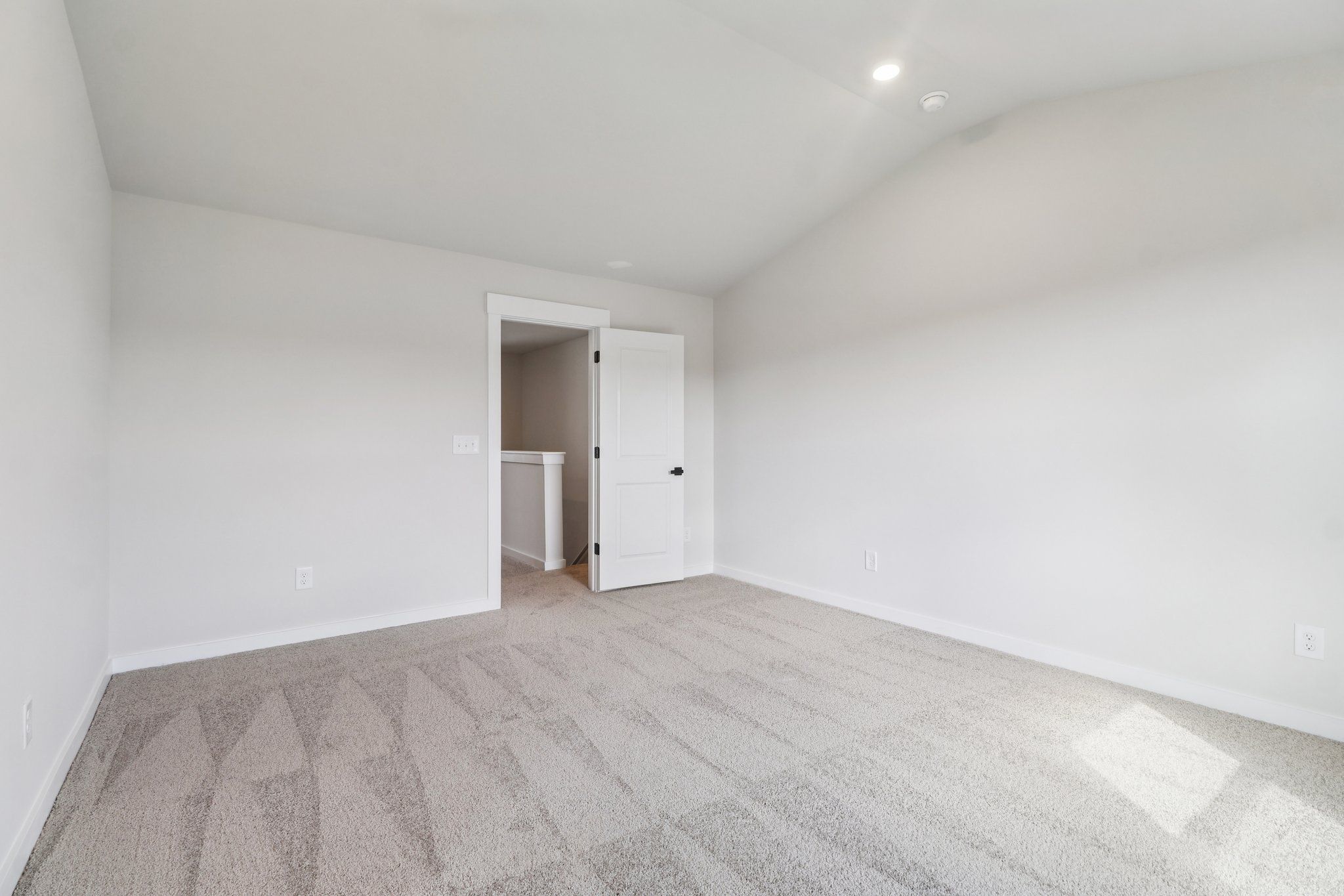 The master bedroom has large windows and carpet.