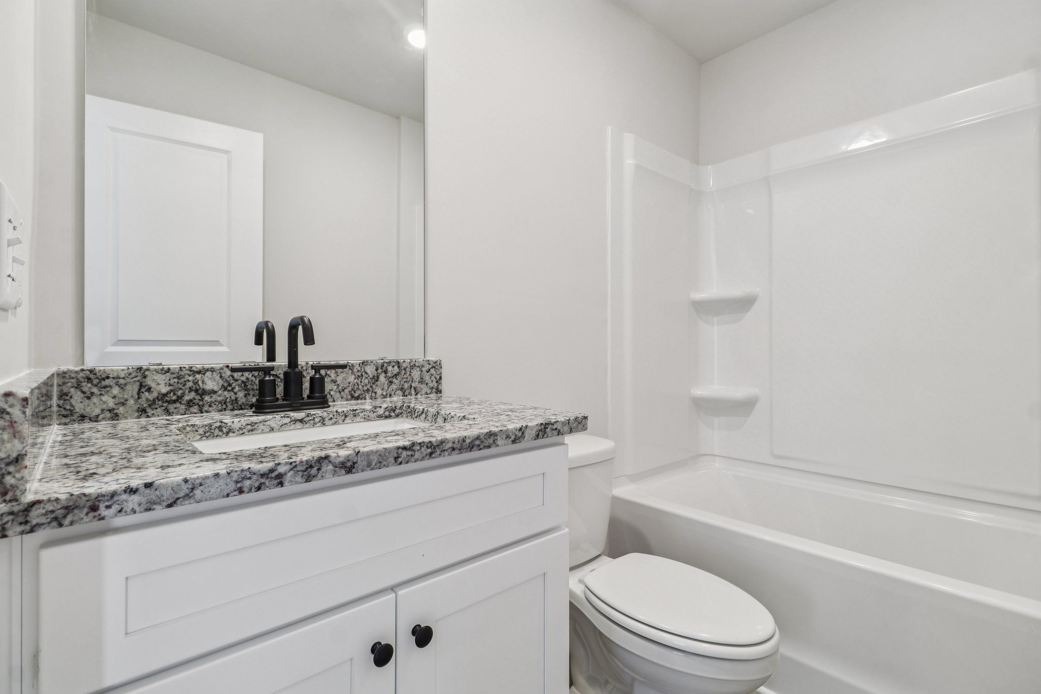 The secondary bathroom has carpet and a large window.