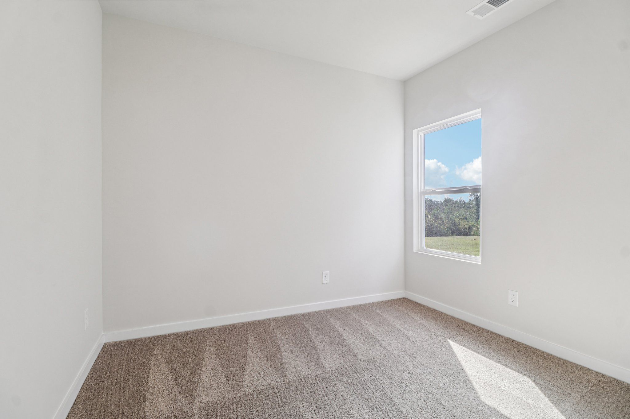 The master bedroom has large windows and carpet.