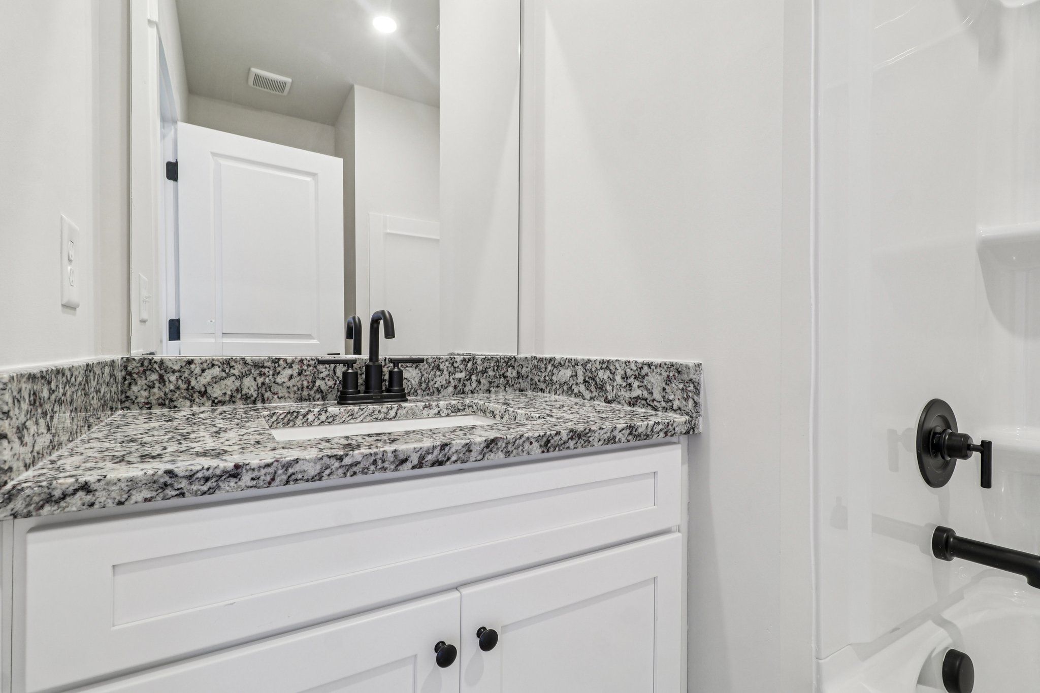 The secondary bathroom has carpet and a large window.