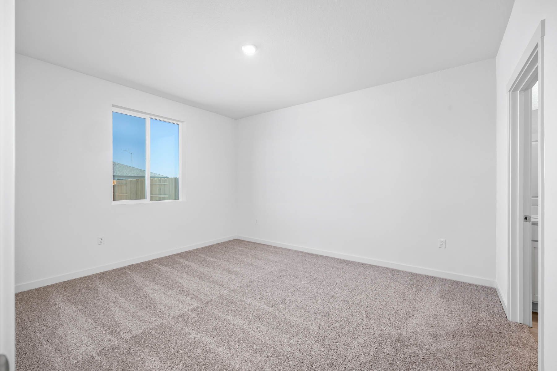 The master bedroom is spacious and has carpet.