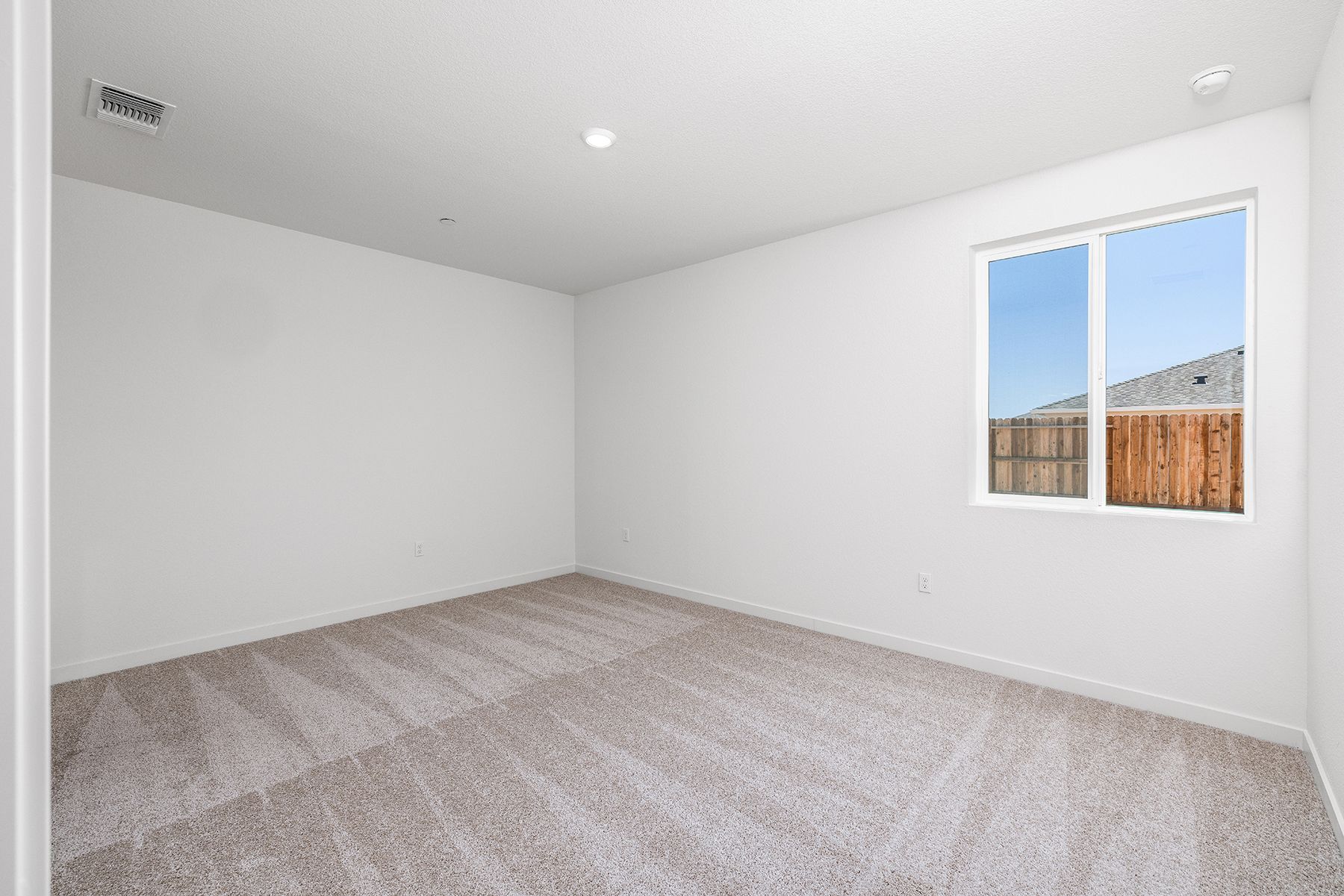 The master bedroom is spacious and has carpet.