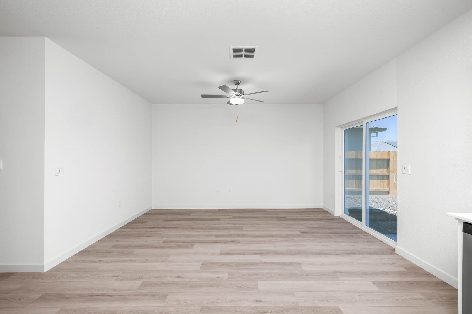 The family room is spacious with a ceiling fan.