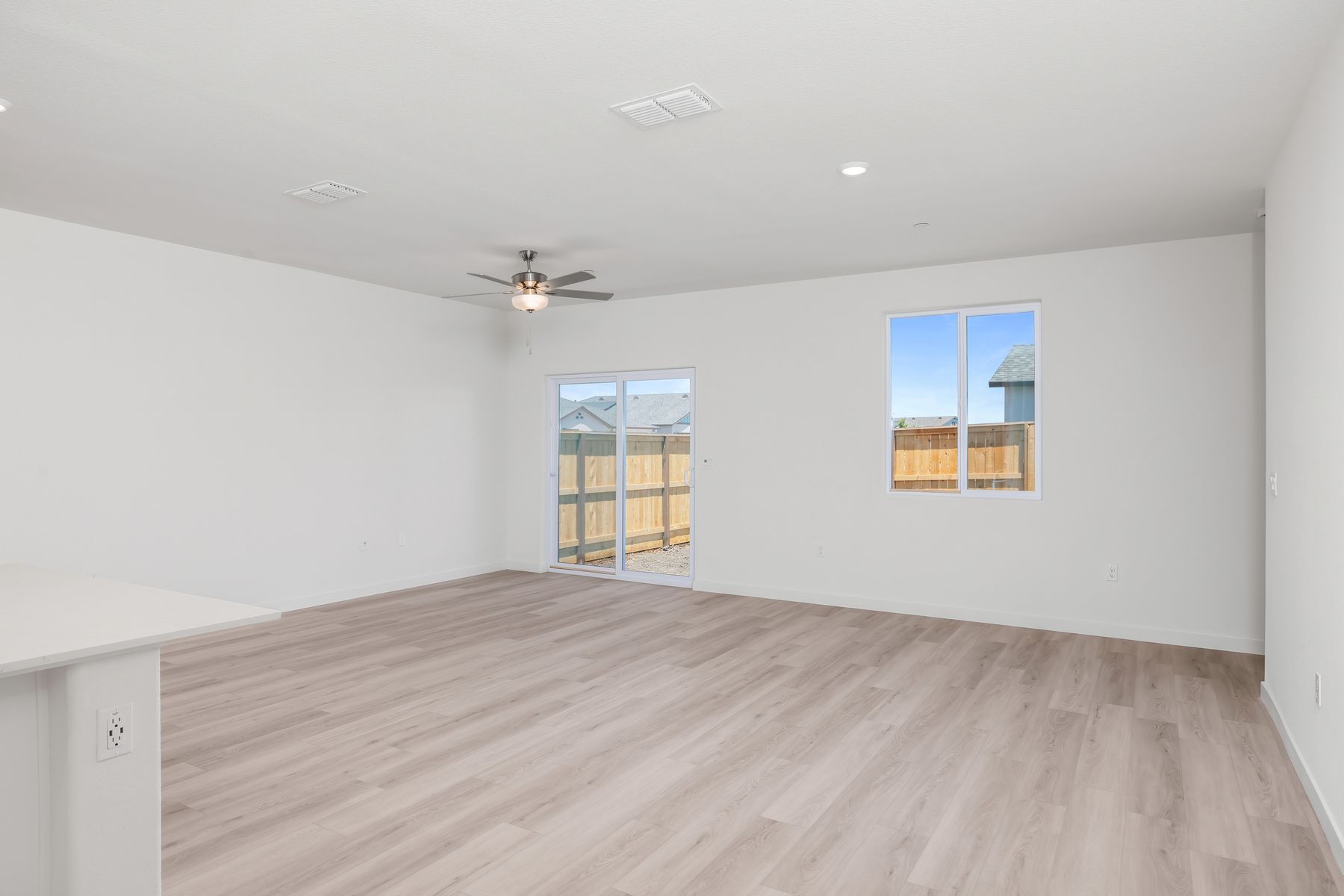 The family room is spacious with a ceiling fan.