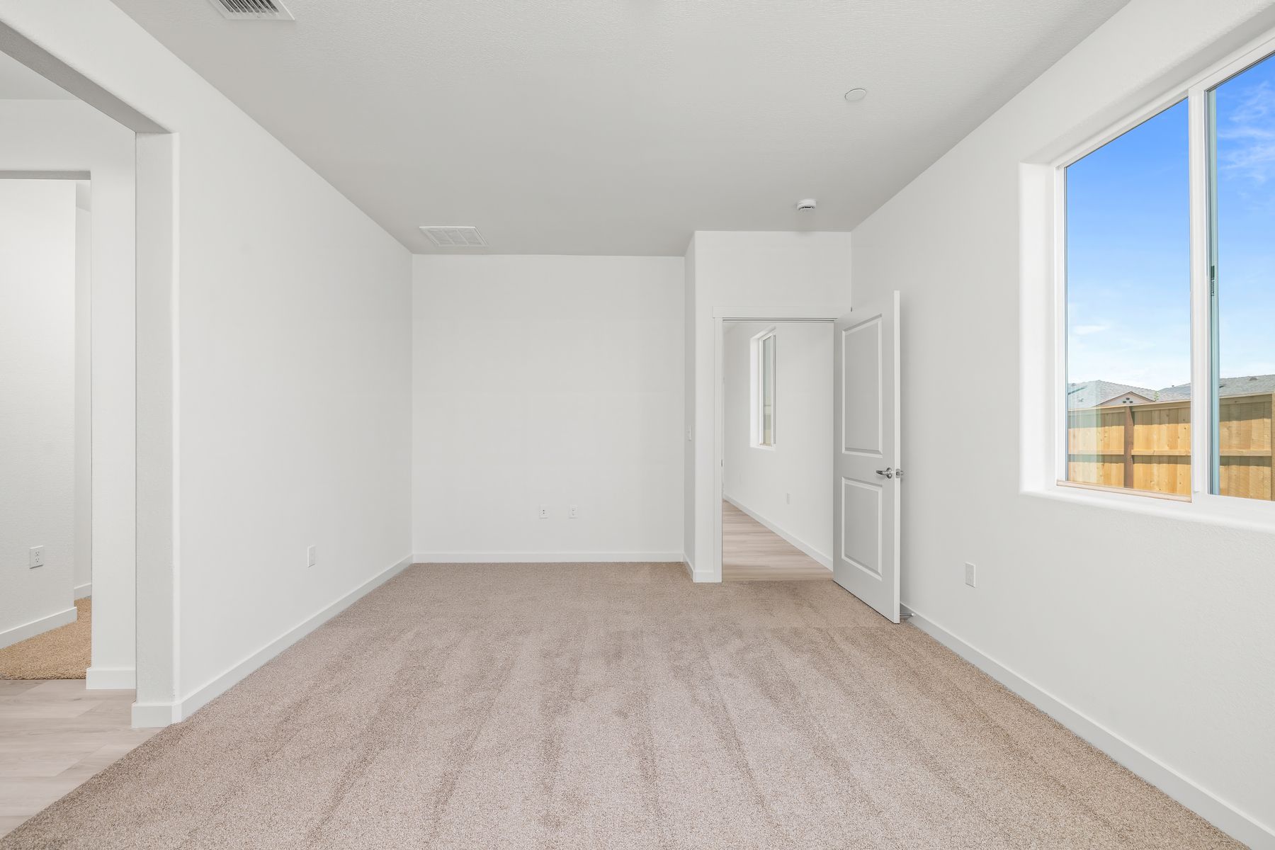 The master bedroom is spacious and has carpet.