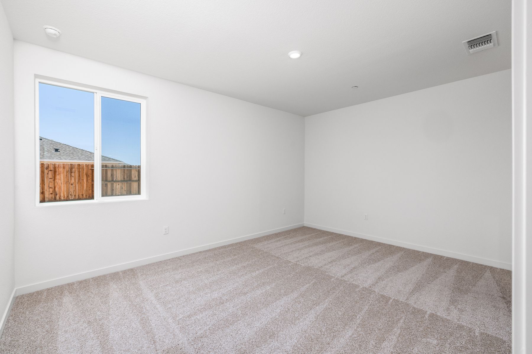 The master bedroom is spacious and has carpet.