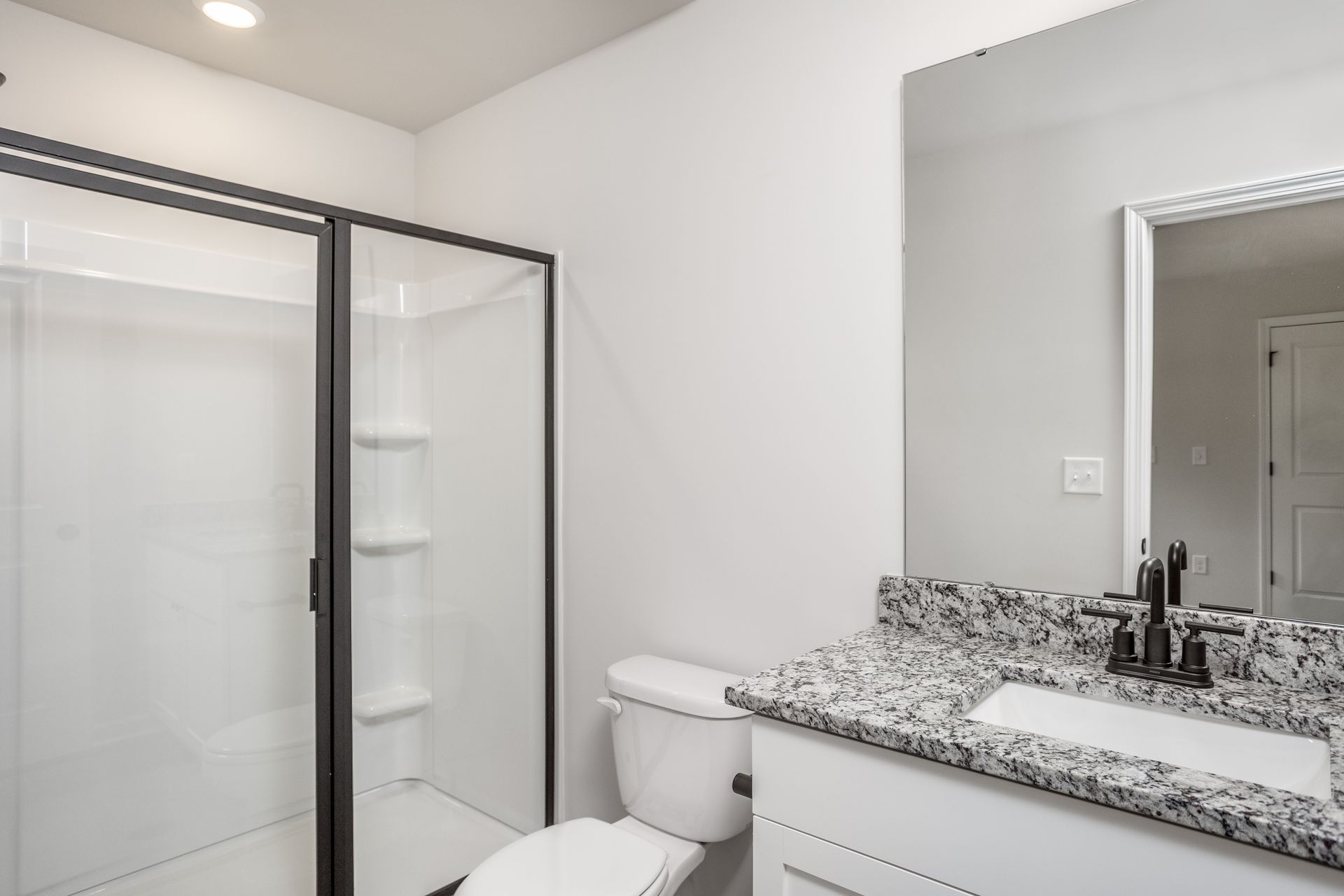 The master bathroom has a glass-enclosed shower. 