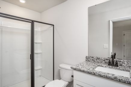 The master bathroom has a glass-enclosed shower.