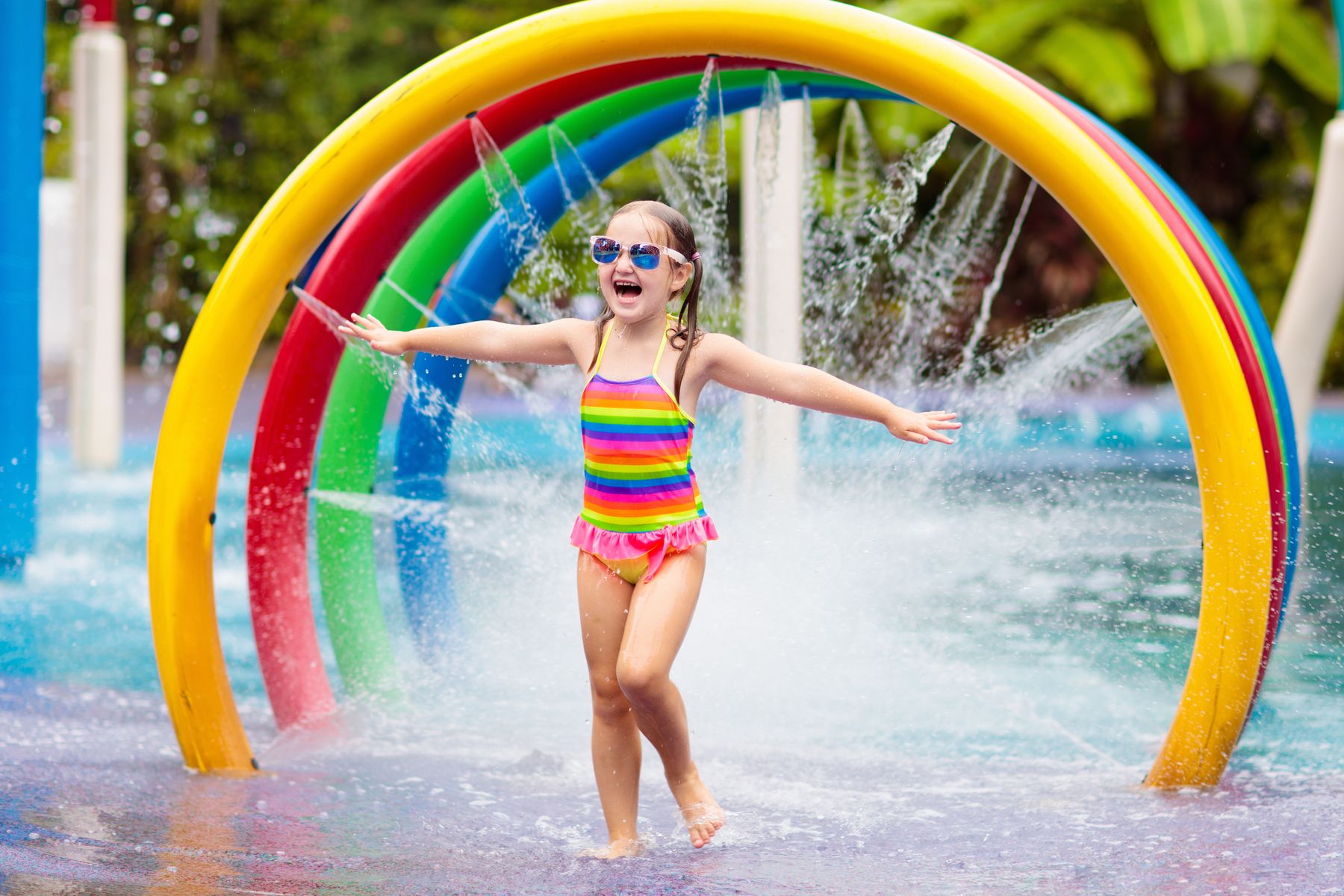 Girl playing in colorful splash pad.