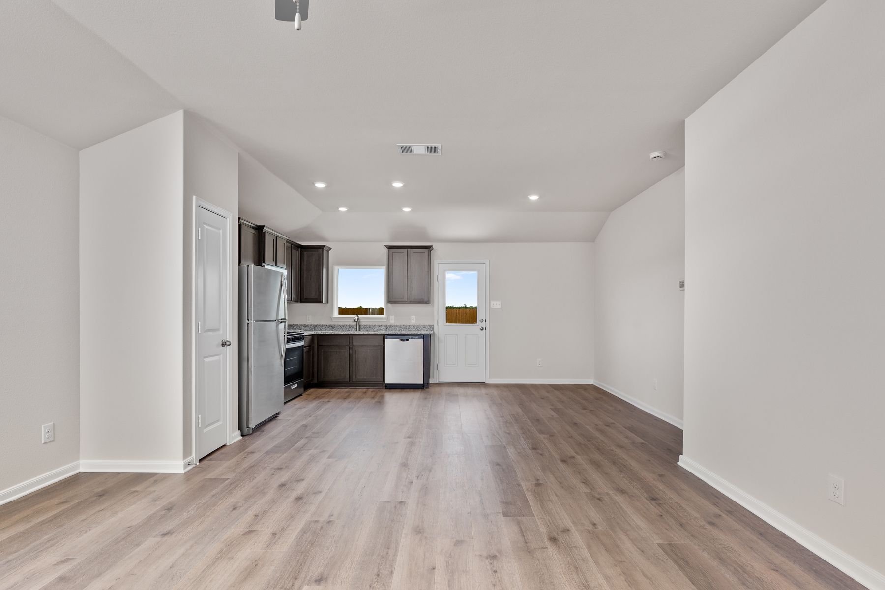 The kitchen, dining room and living room sit adjacent to one another.