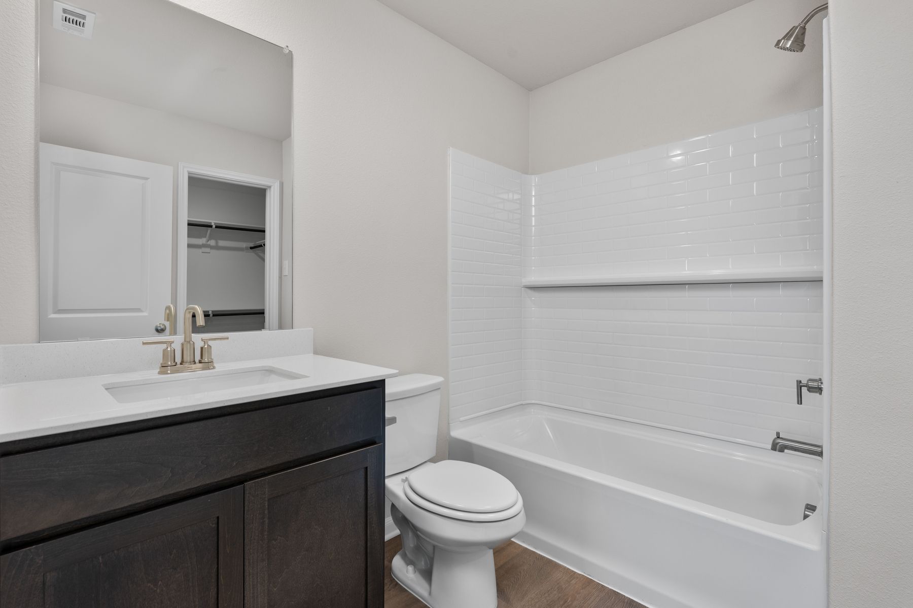 The master bathroom has a great vanity space with a shower-tub combo.