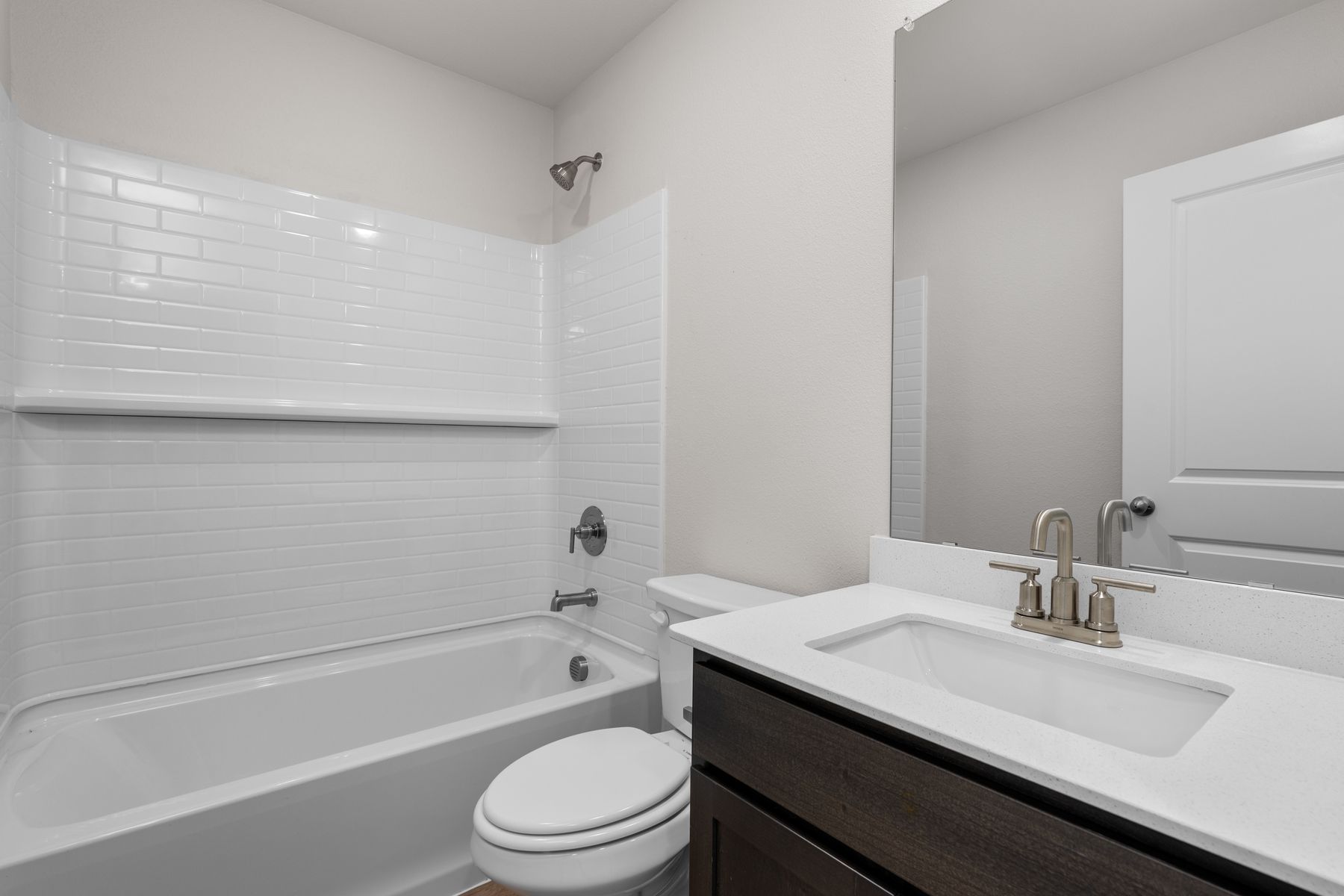 The secondary bathroom has a vanity space and a shower-tub combo.