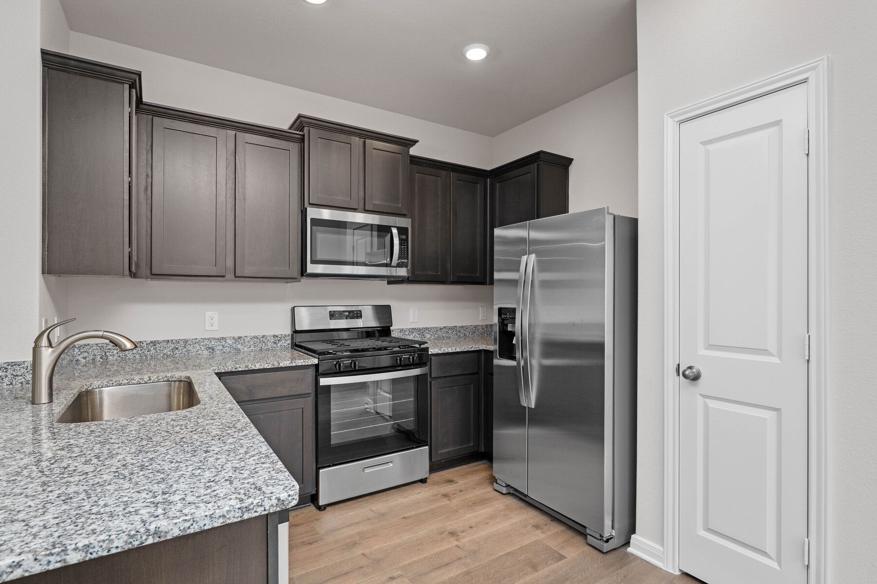 The kitchen  has designer wood cabinetry.